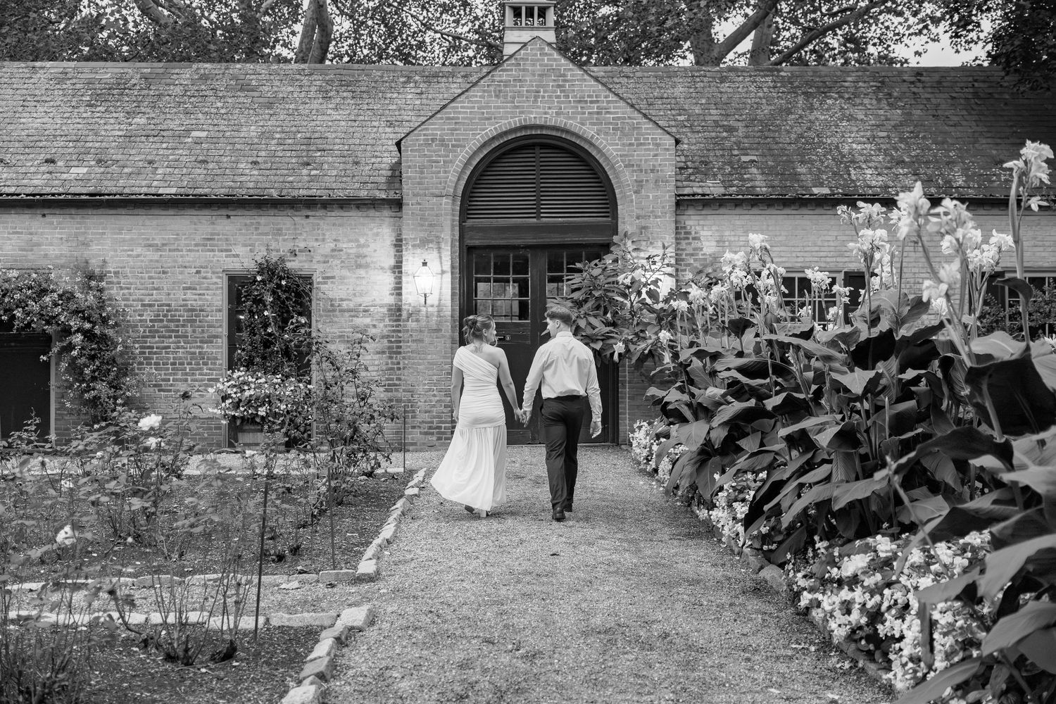 Engaged couple walking hand in hand through the gardens at Conestoga House and Gardens in Lancaster, Pennsylvania, photographed.