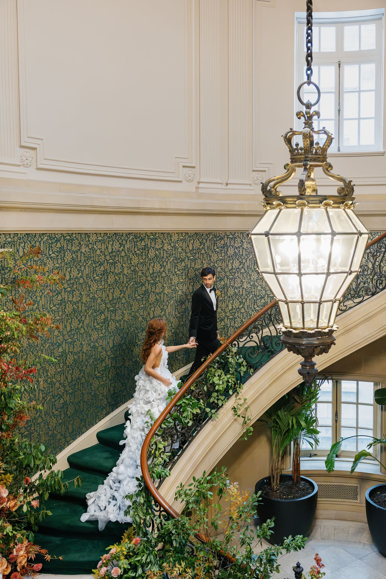 Bride and groom walking the grand staircase inside Elkins Estate, featuring the venue’s historic architecture near Philadelphia.