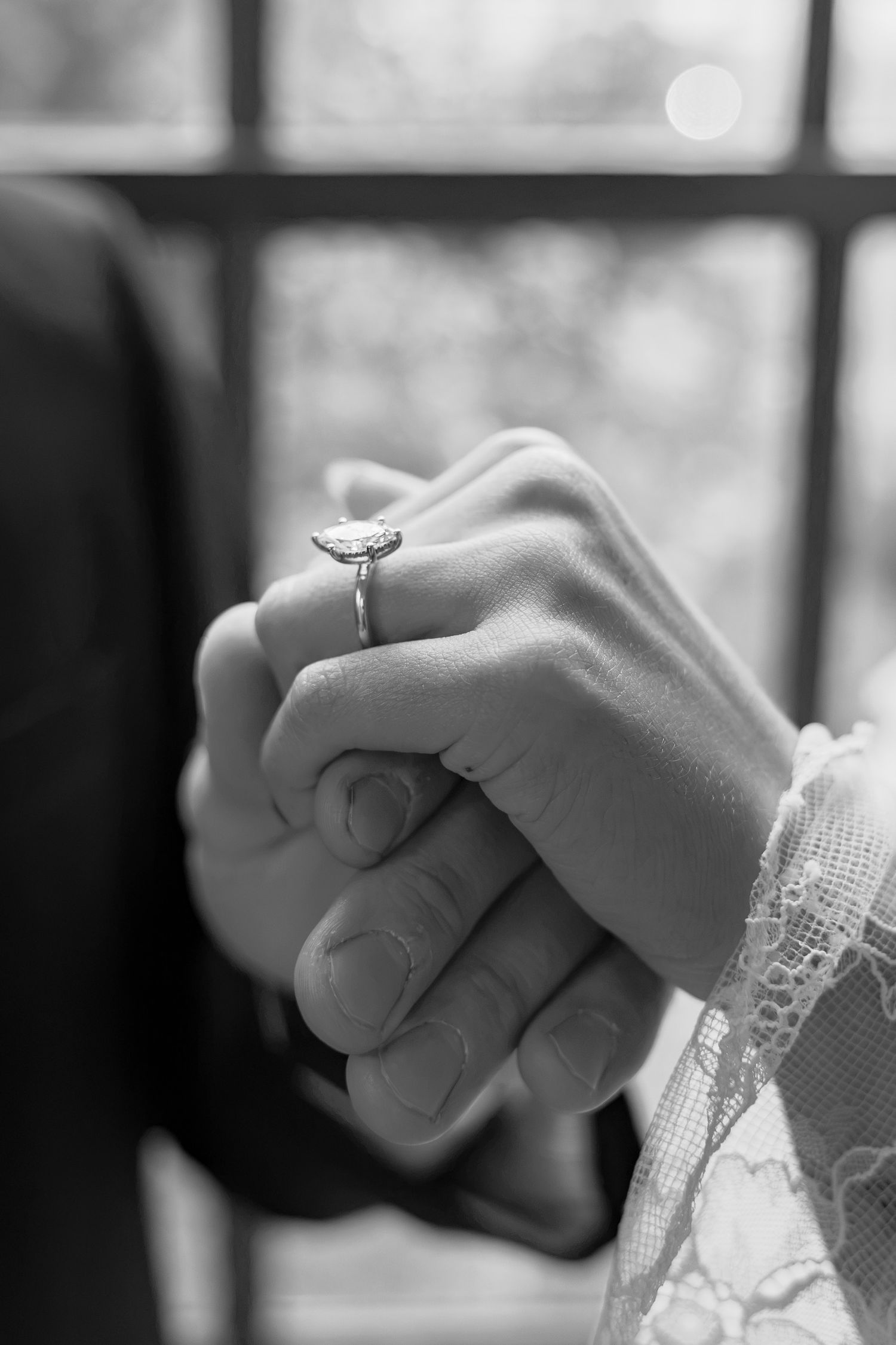 Black and white close-up of an engaged couple holding hands during their Conestoga House engagement session in Lancaster, PA.