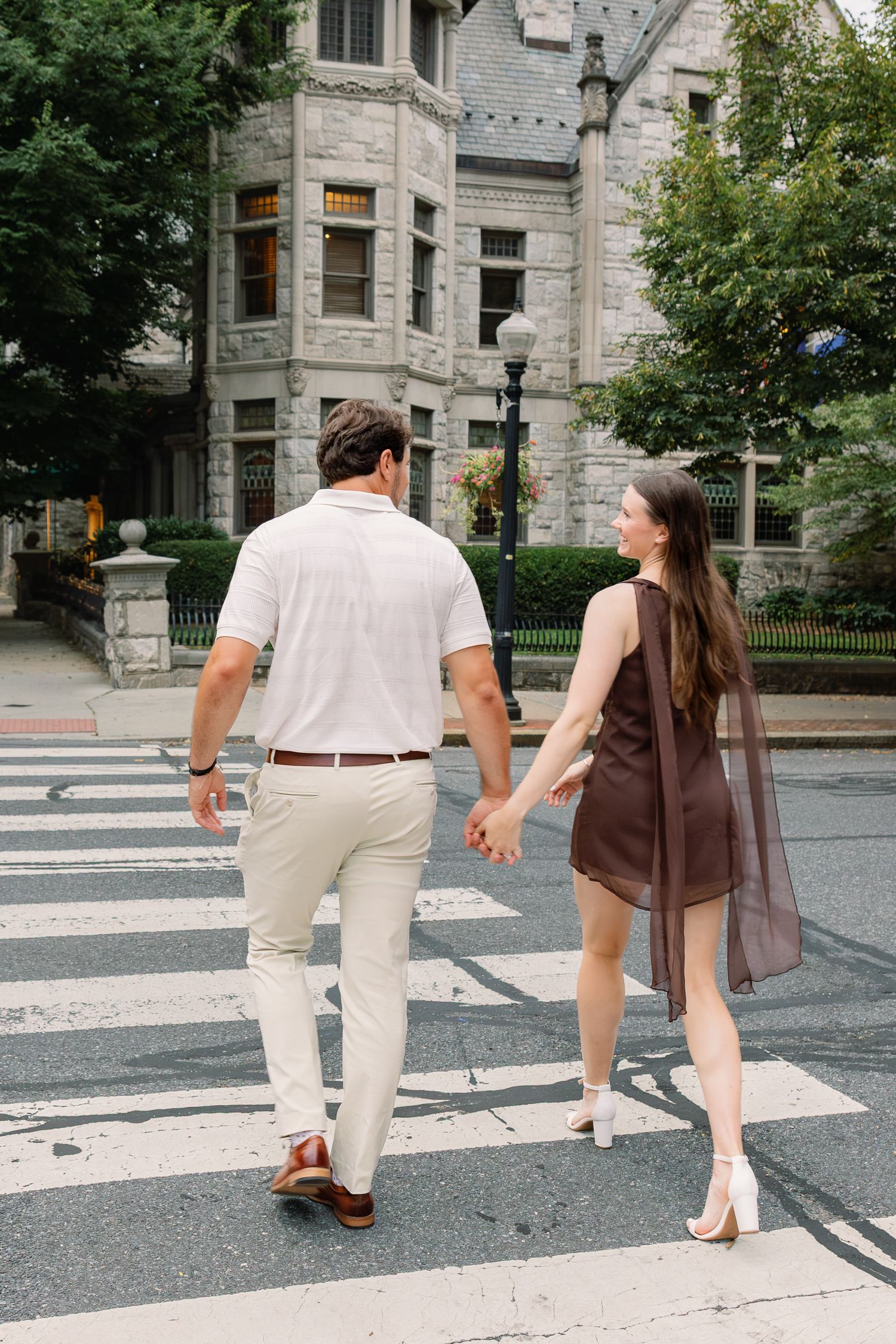 Engaged couple walking hand in hand through downtown Lancaster, Pennsylvania during their engagement session