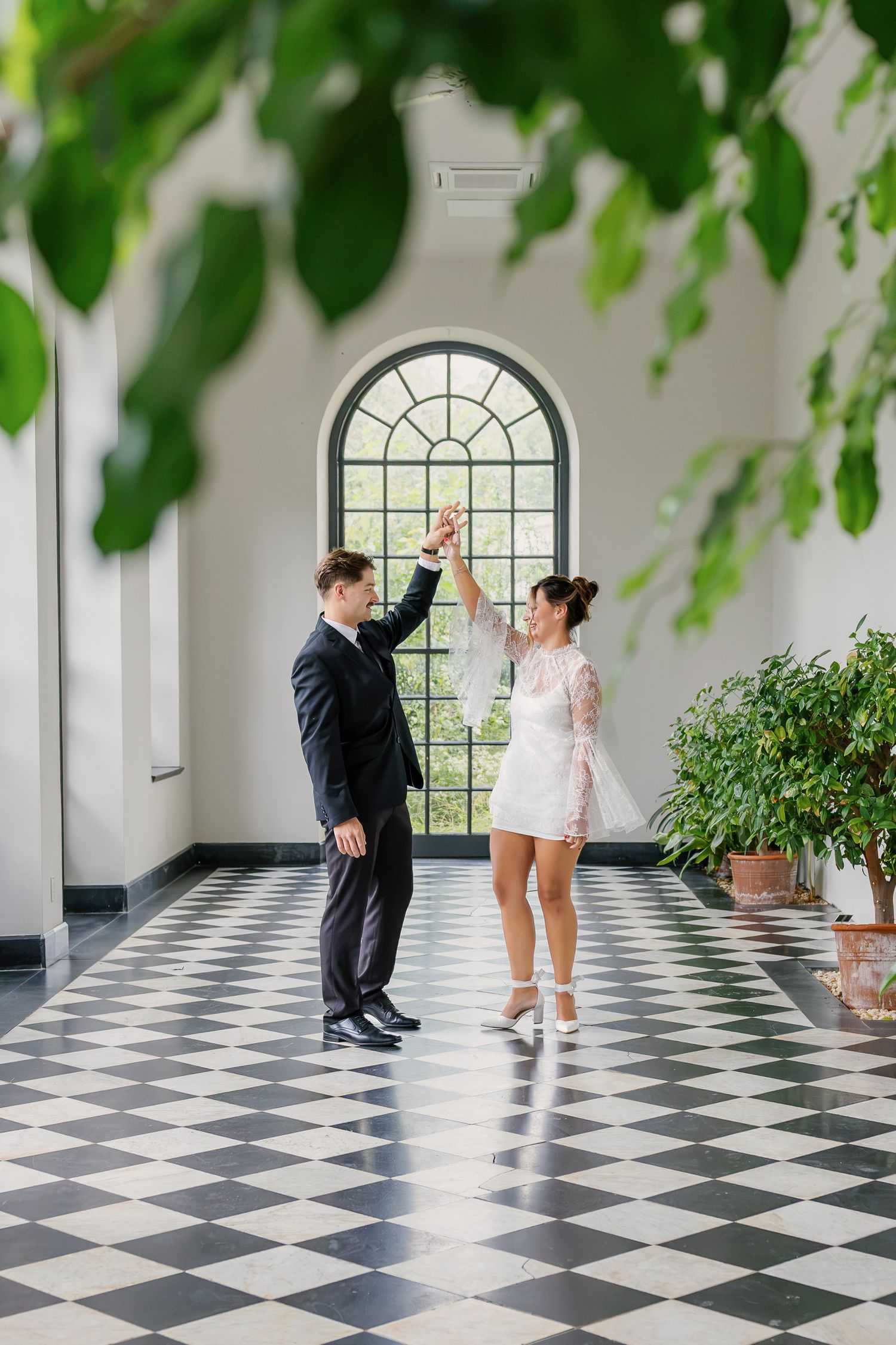 Engaged couple walking along the black and white tiled corridor at Conestoga House and Gardens in Lancaster, Pennsylvania.
