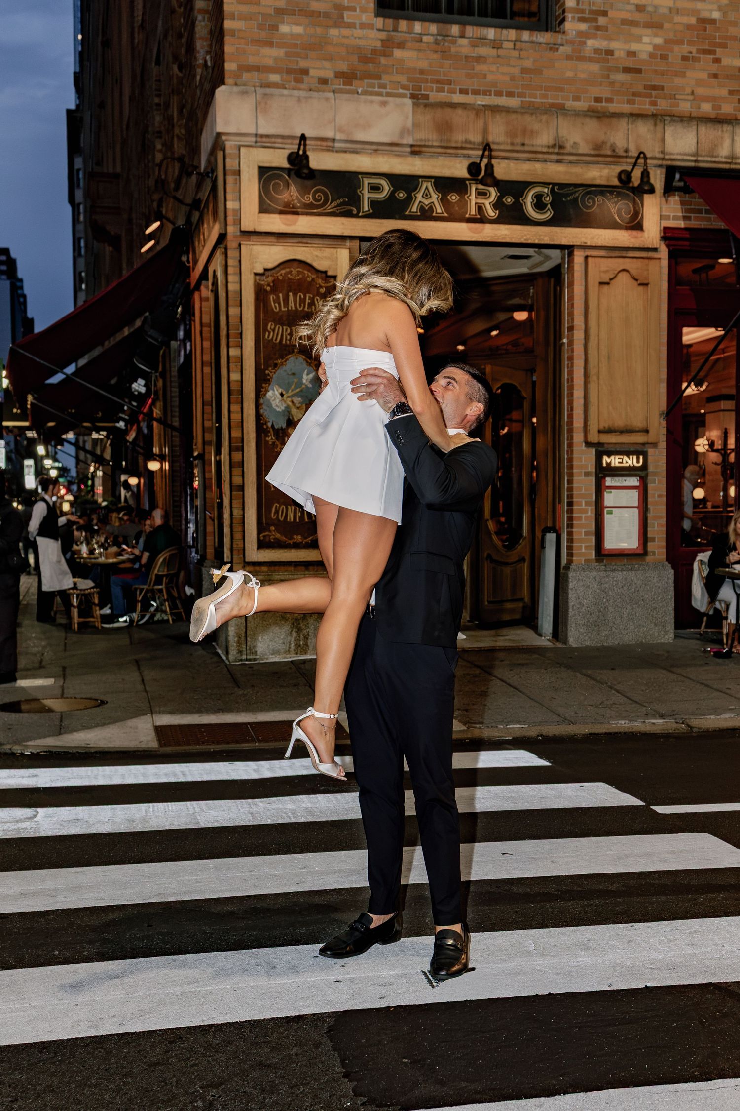 Couple embracing on the steps outside a Philadelphia restaurant during their editorial-style engagement photo session.