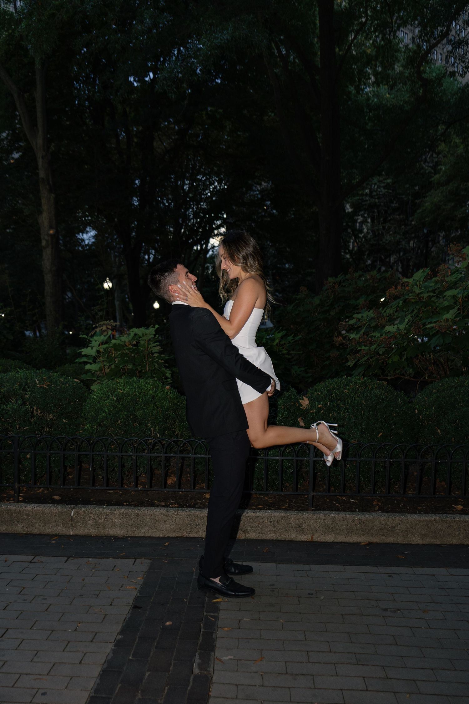 Romantic engagement portrait of a couple embracing beneath the trees in Rittenhouse Square, Philadelphia.