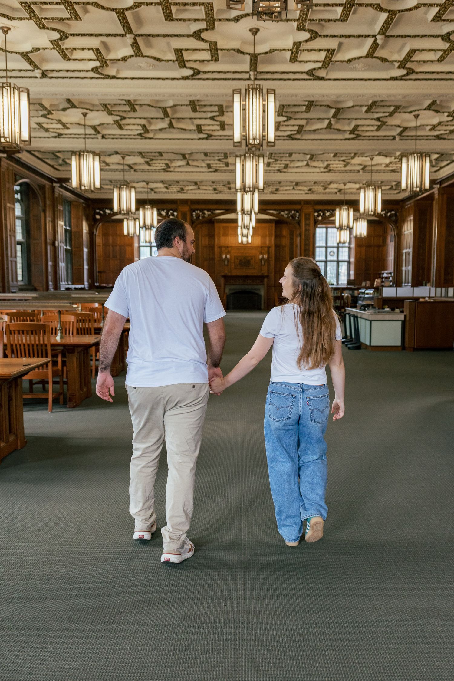 Couple walking hand in hand inside historic Linderman Library at Lehigh University in Bethlehem, Pennsylvania.