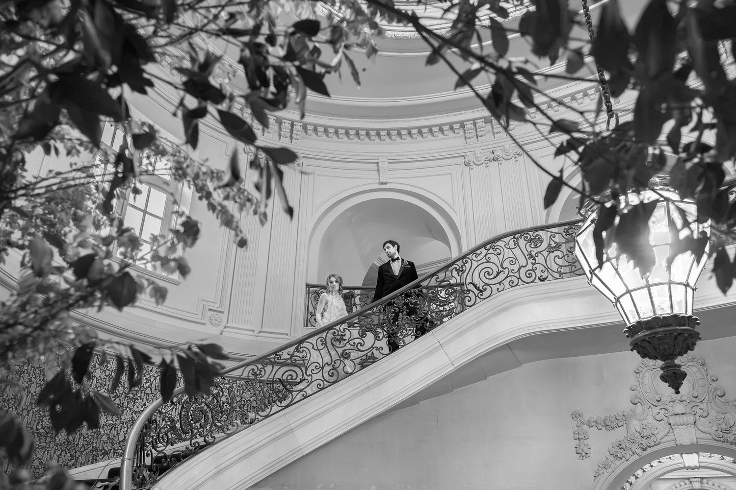 Black and white wedding portrait on the grand staircase inside Elkins Estate, a historic wedding venue near Philadelphia.