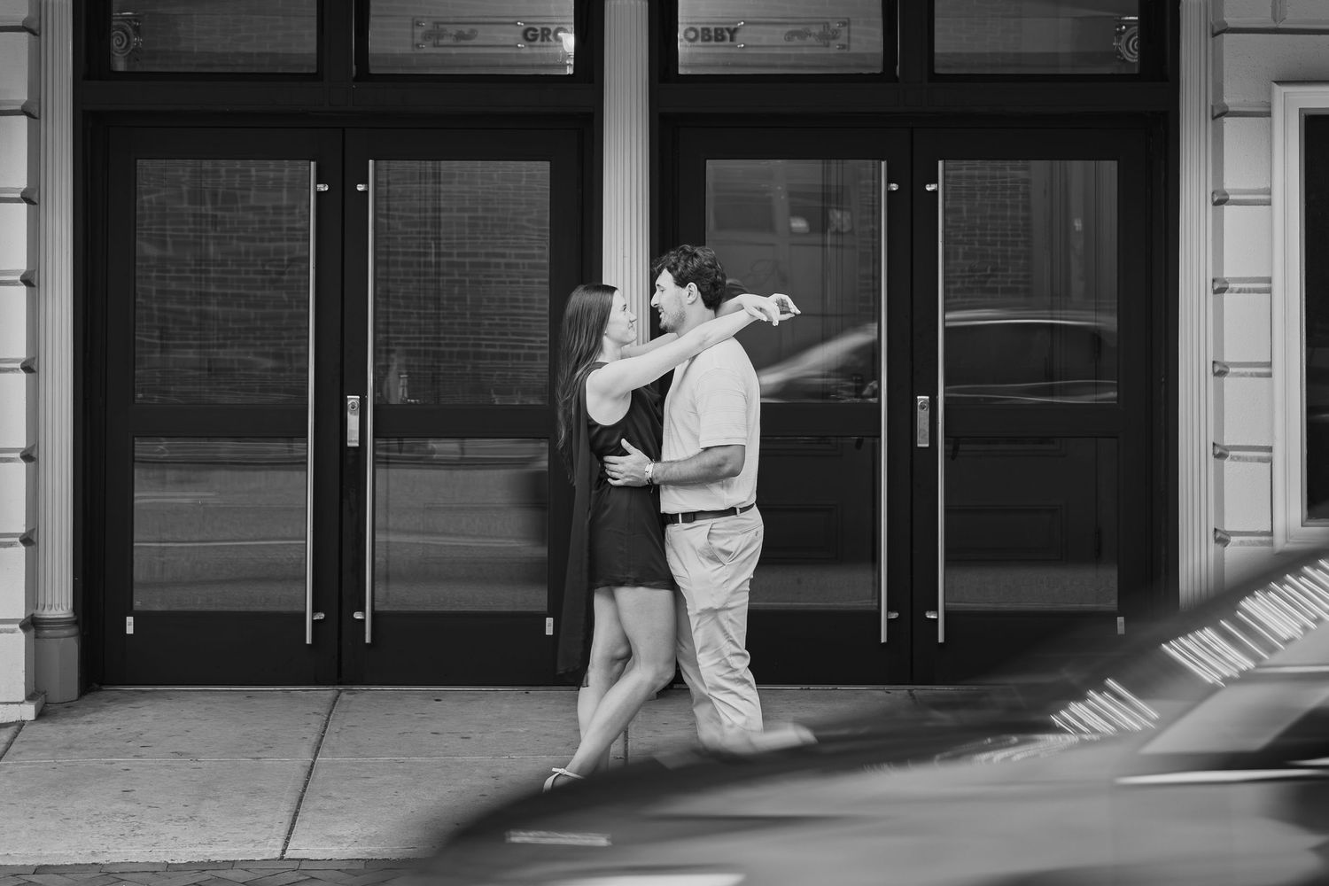 Black and white photo of a couple sharing a playful moment during a downtown Lancaster PA couples photography session
