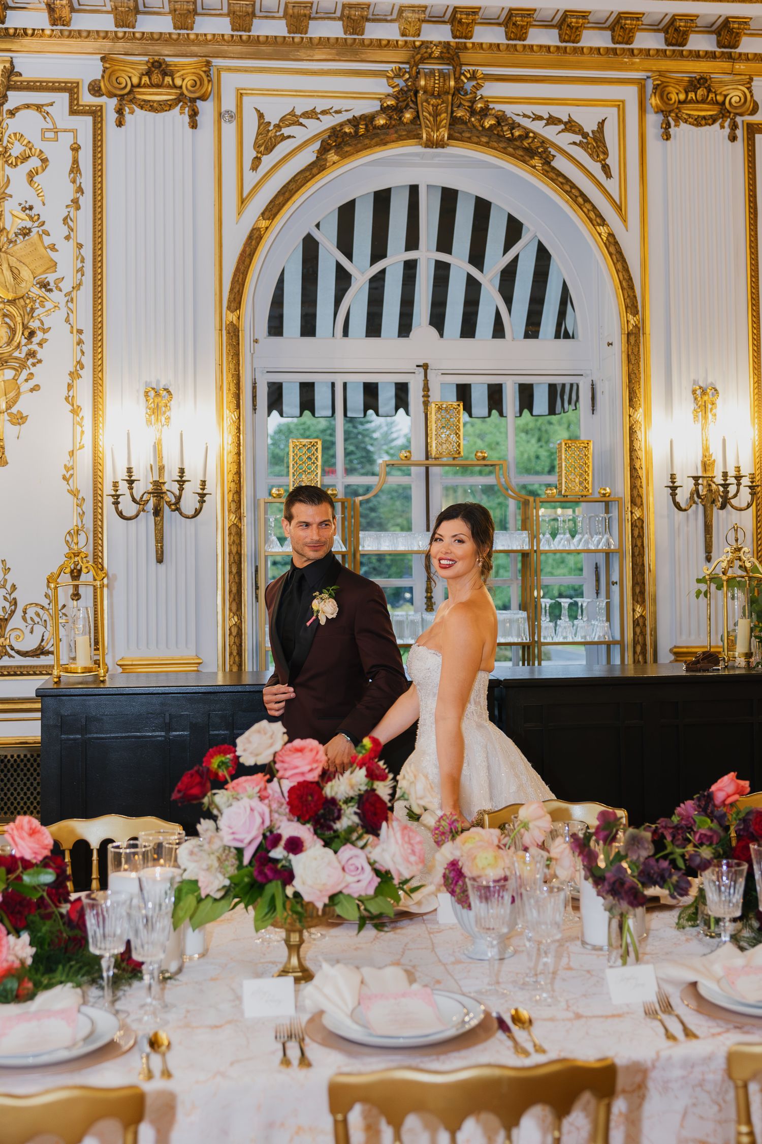 Bride and groom at an elegant reception table inside the ornate Elkins Estate wedding venue near Philadelphia.