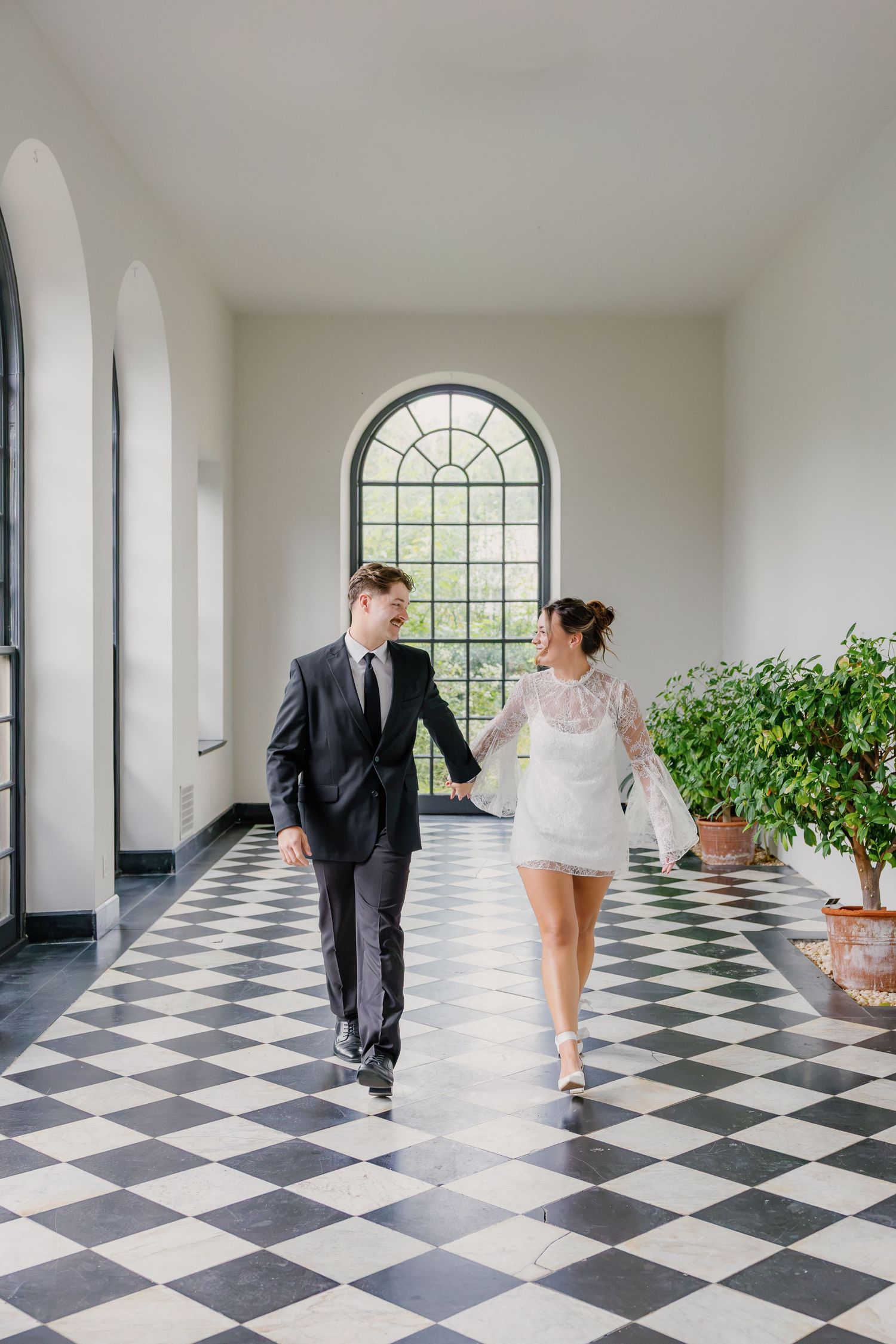 Engaged couple walking together inside Conestoga House and Gardens in Lancaster, Pennsylvania, photographed on the black and white checkered