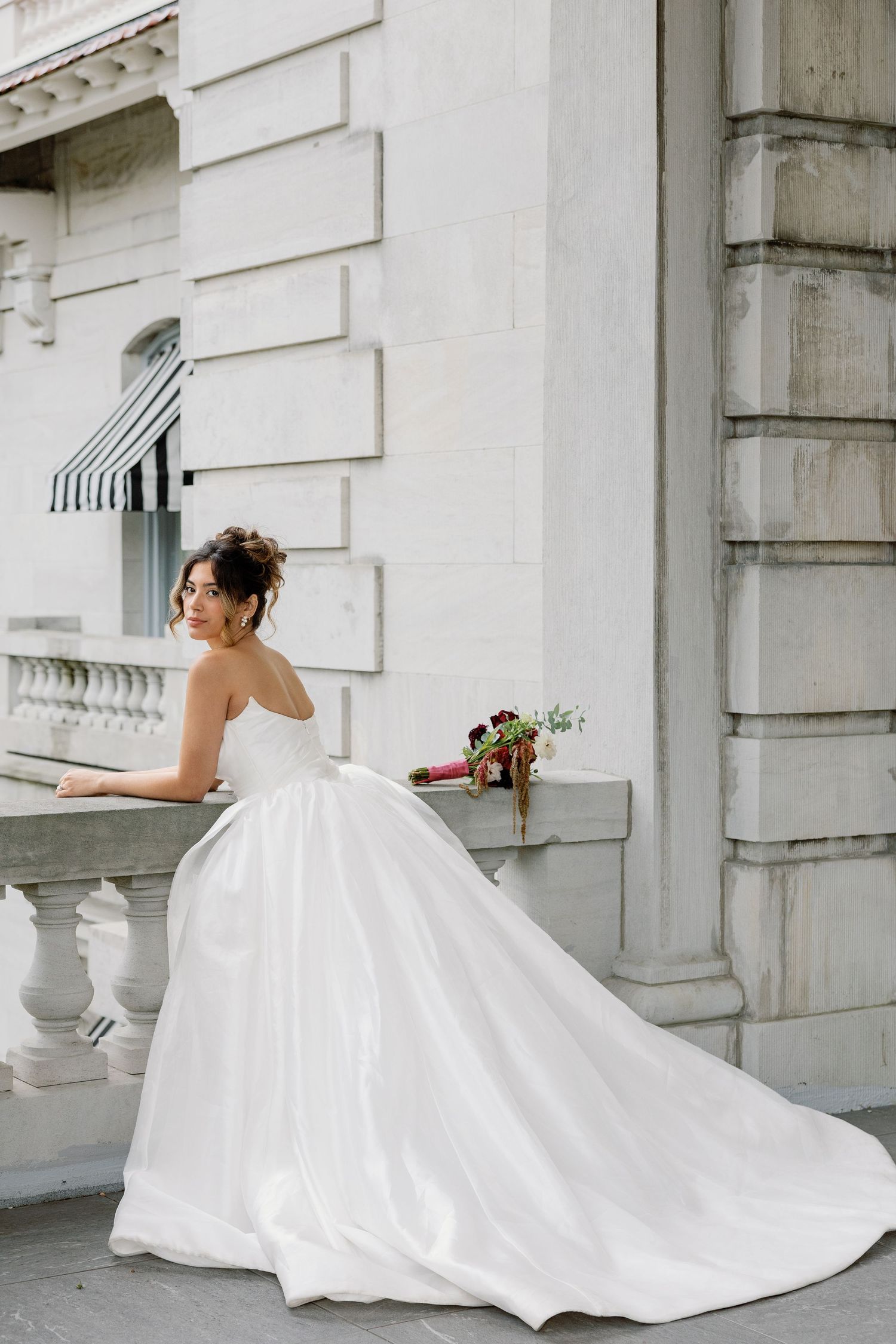 Editorial bridal portrait outside Elkins Estate in Elkins Park, Pennsylvania, featuring a lace wedding gown and the European-inspired archit