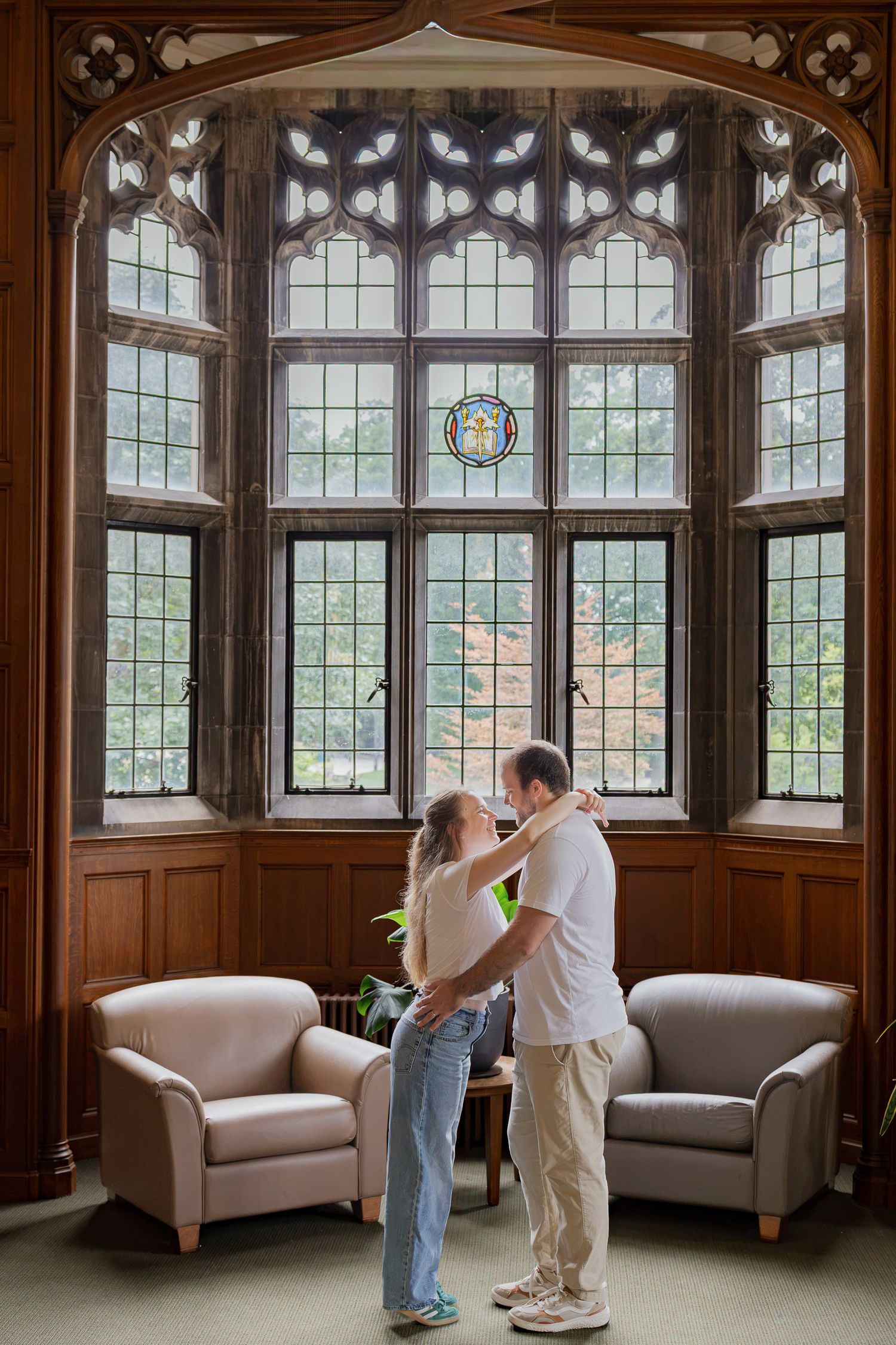Couple embracing beneath the arched windows inside Linderman Library at Lehigh University in Bethlehem, Pennsylvania