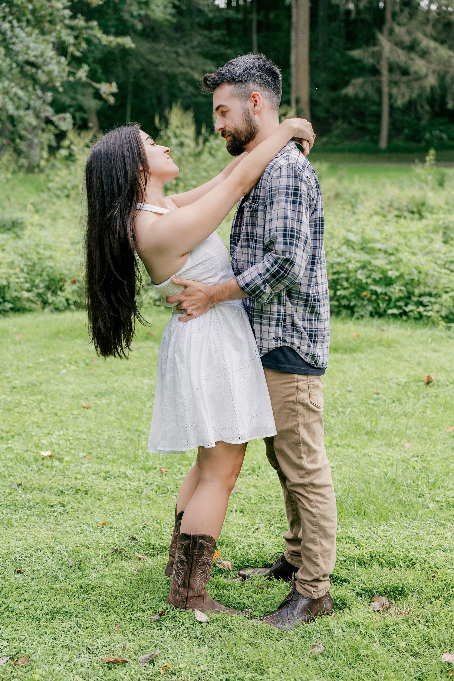 Couple embracing in a grassy field during a romantic Pennsylvania couples engagement photography session
