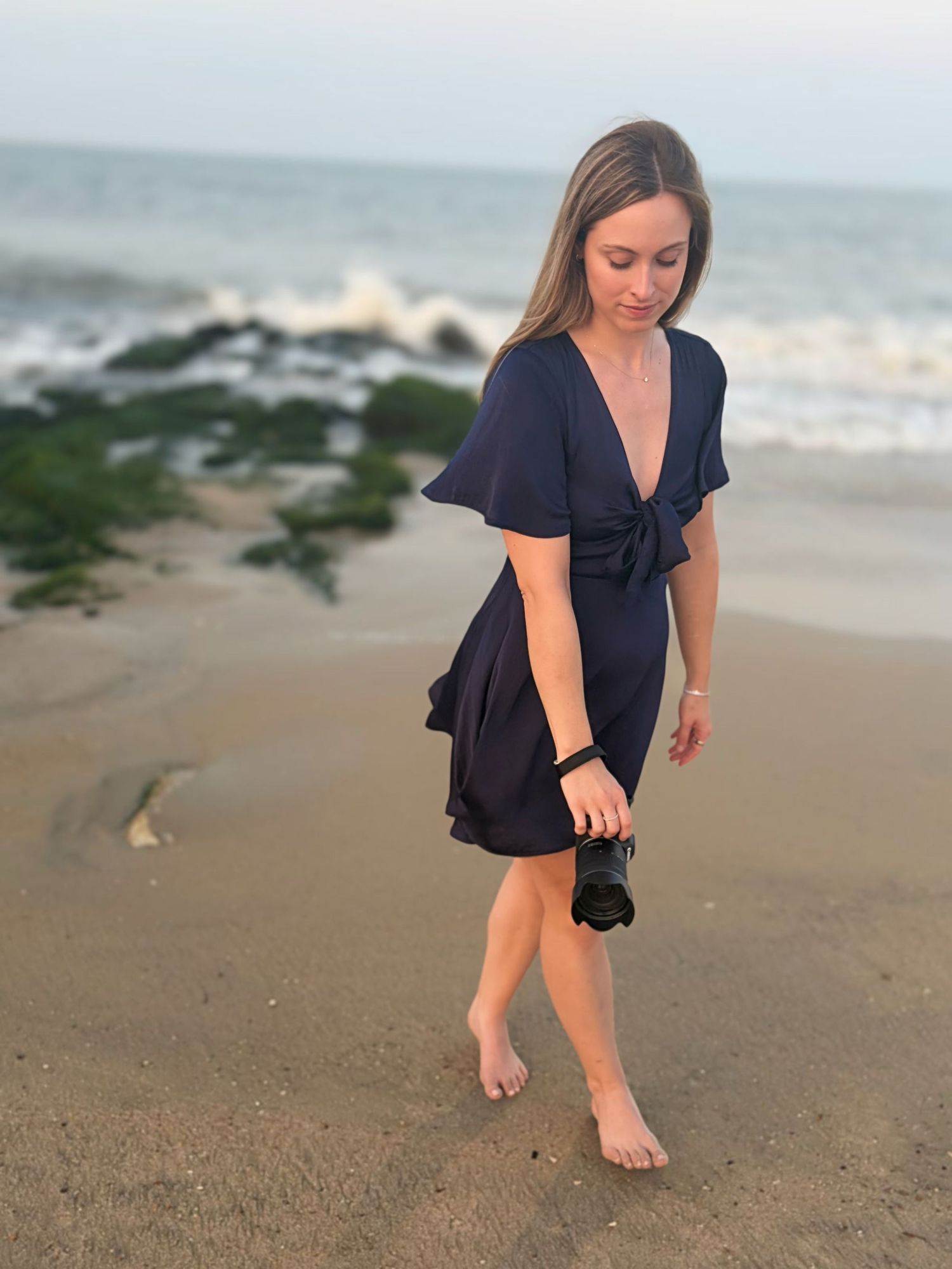 Woman walking along the shoreline during a natural beach portrait photography session