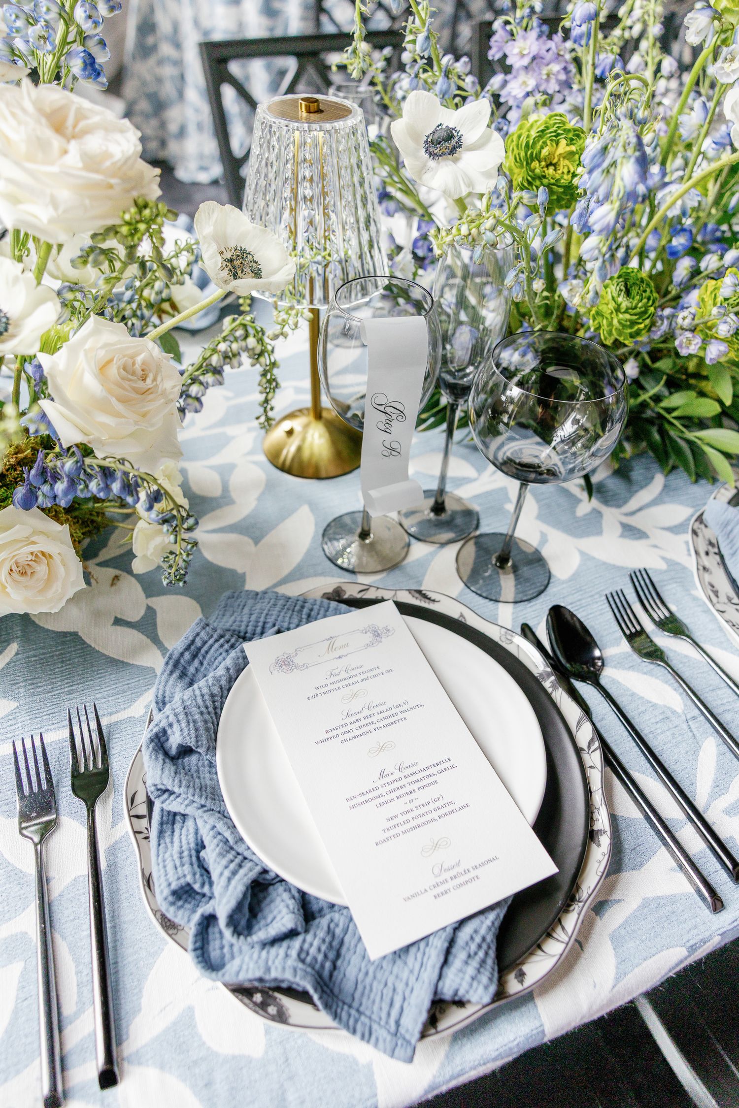 Elegant wedding place setting with black details and white florals at an editorial wedding reception at Elkins Estate in Pennsylvania.