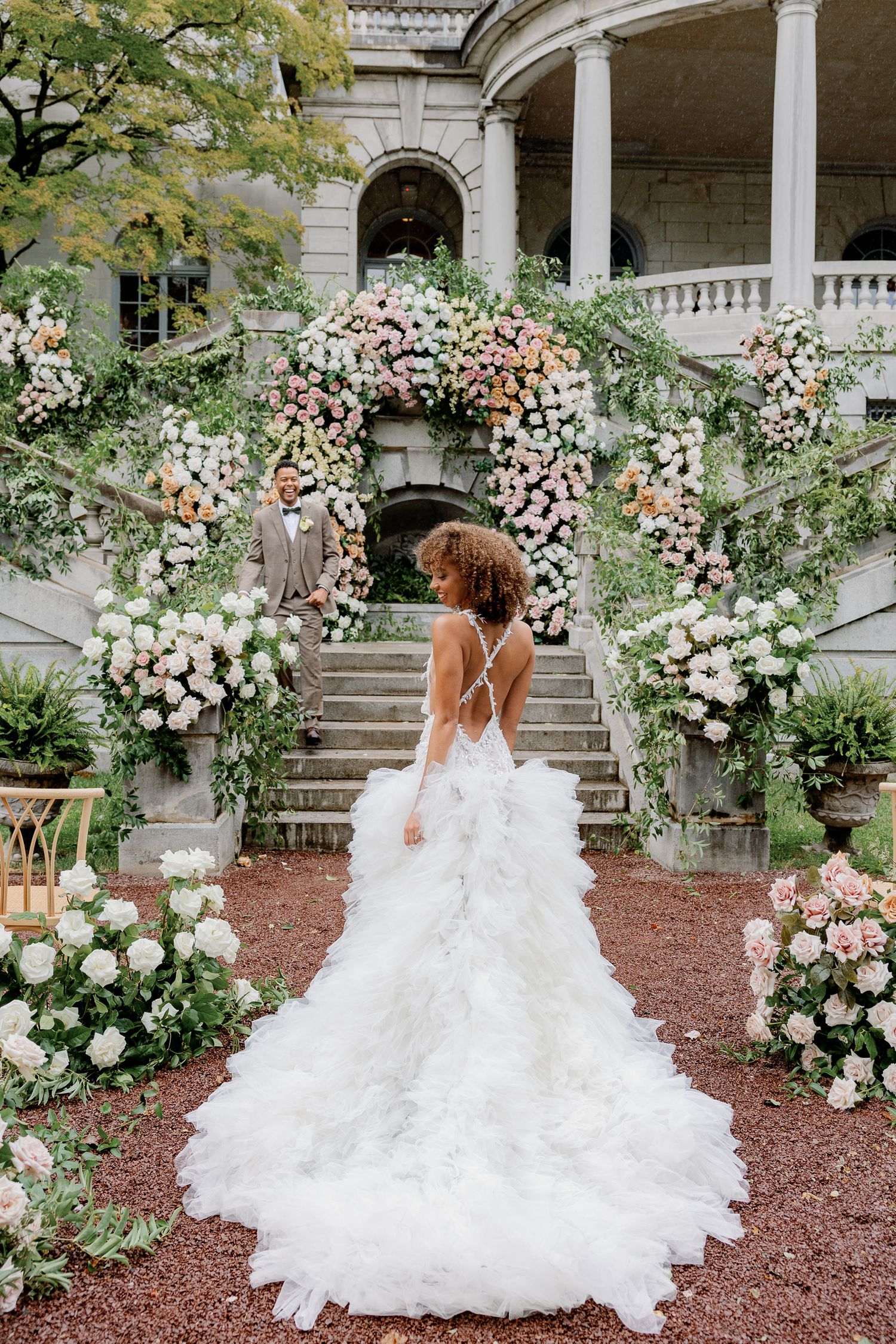 Bride in a romantic wedding gown surrounded by lush floral arrangements at Elkins Estate, a historic wedding venue near Philadelphia, Pennsy