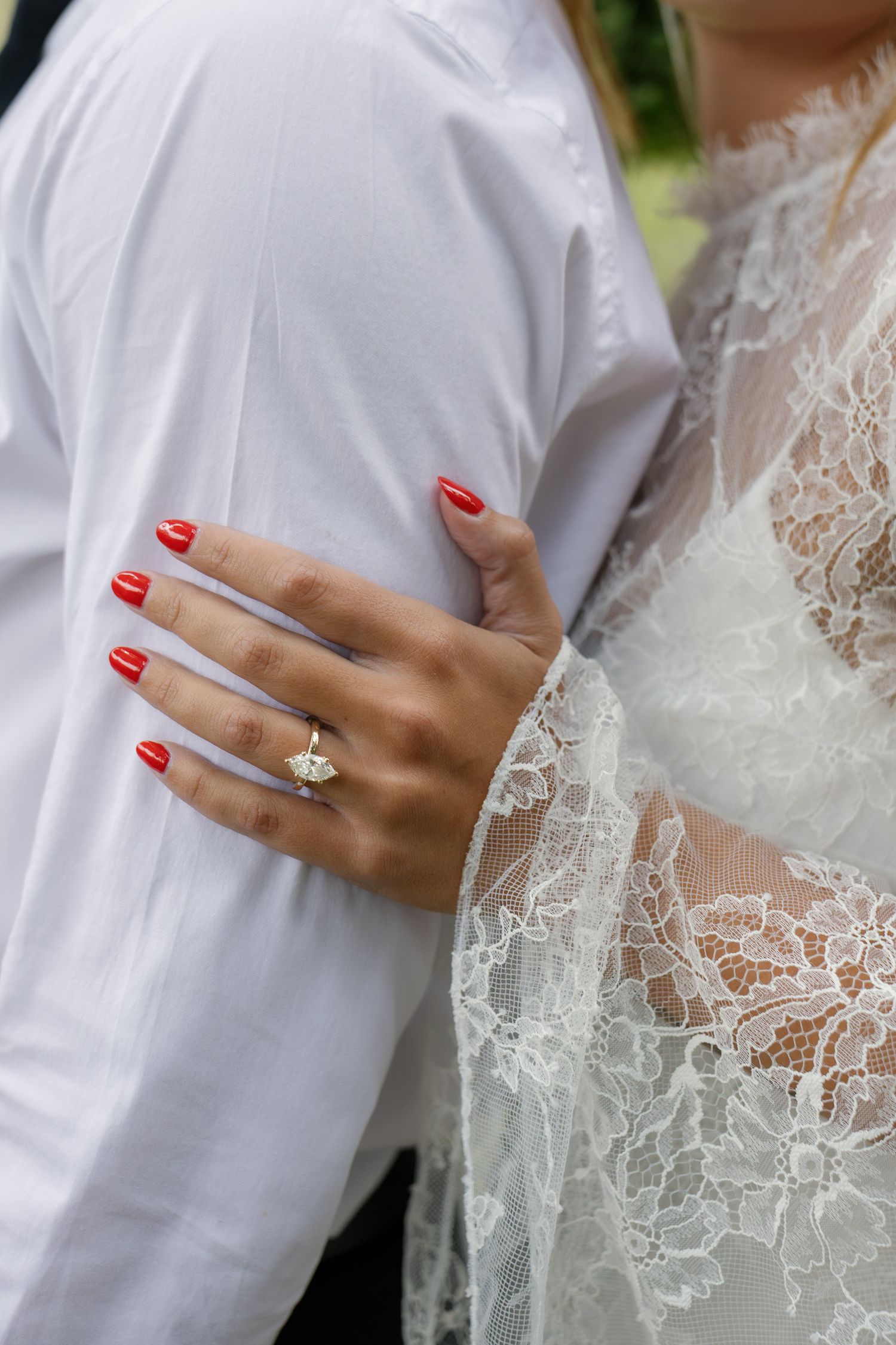 Close-up engagement photo highlighting an engagement ring as the couple embraces during their session at Conestoga House and Gardens.