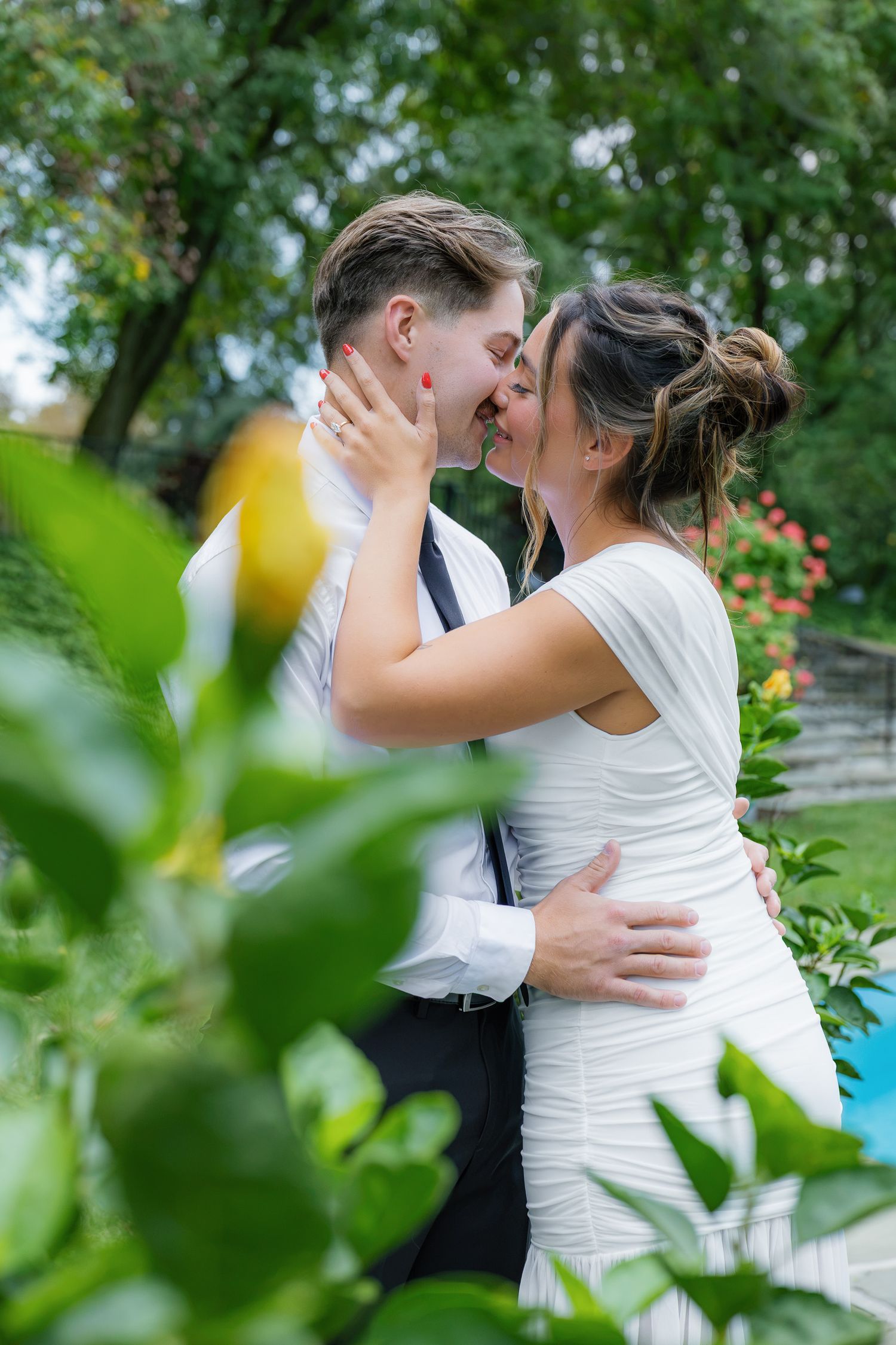 Romantic engagement portrait of a couple embracing among the lush greenery at Conestoga House and Gardens in Lancaster, Pennsylvania.