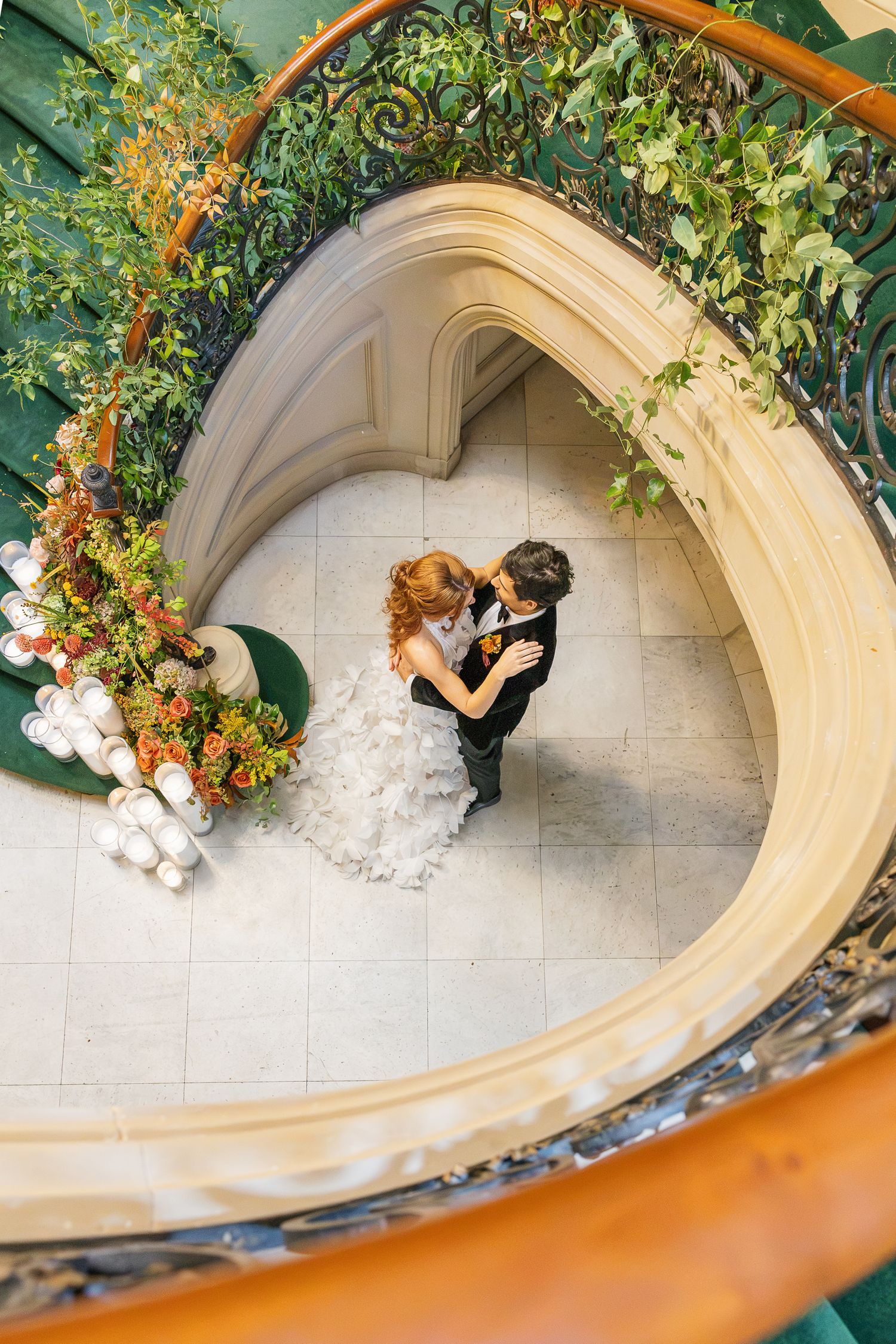 Bride and groom photographed from above on the curved stone staircase at Elkins Estate, a historic Pennsylvania wedding venue.