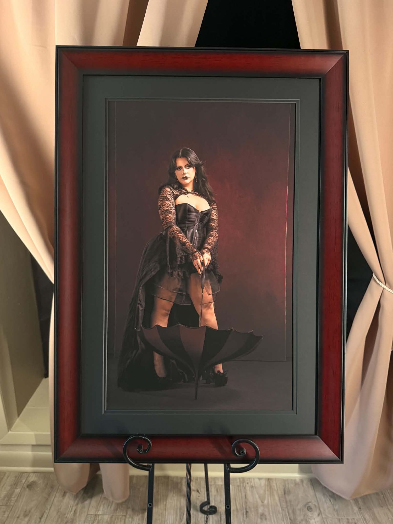 Elegant framed portrait photo of a woman in gothic costume displayed on a wooden easel.