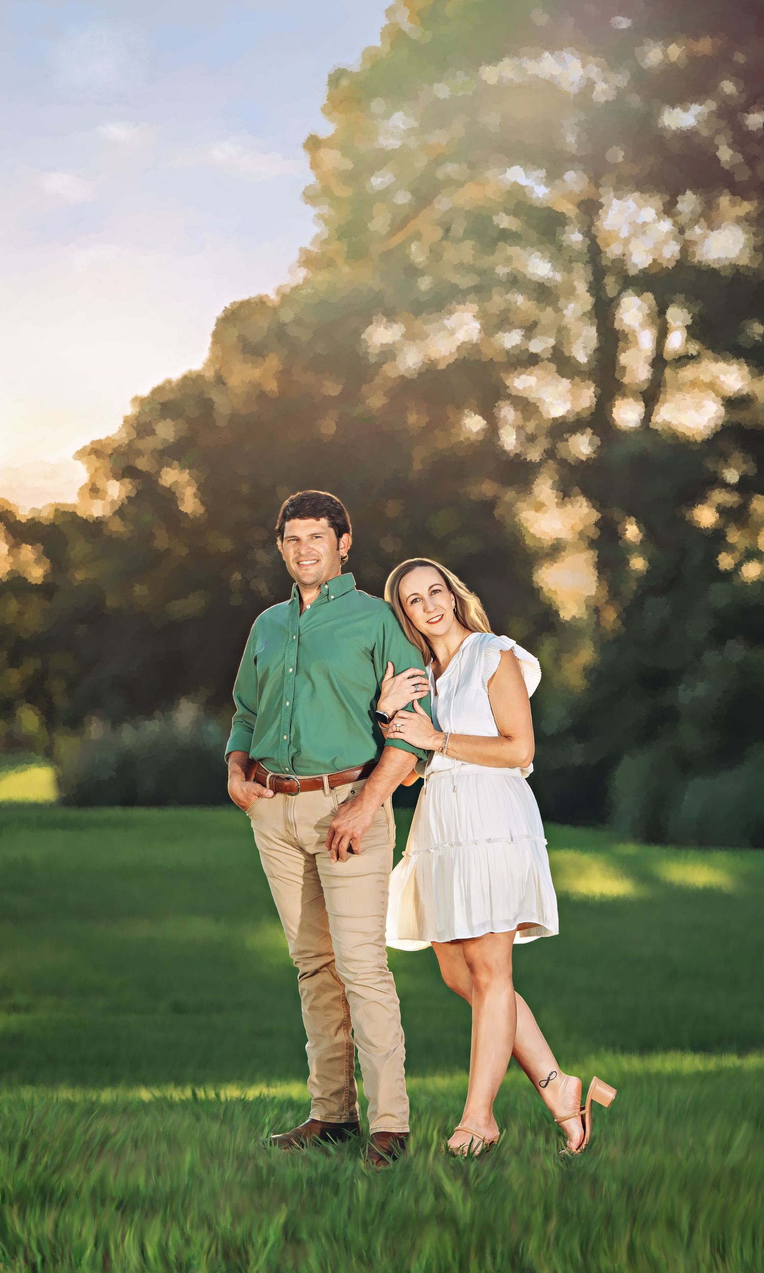 Couple posing outdoors on green grass at golden hour, man in green shirt and woman in white dress, with trees in background.