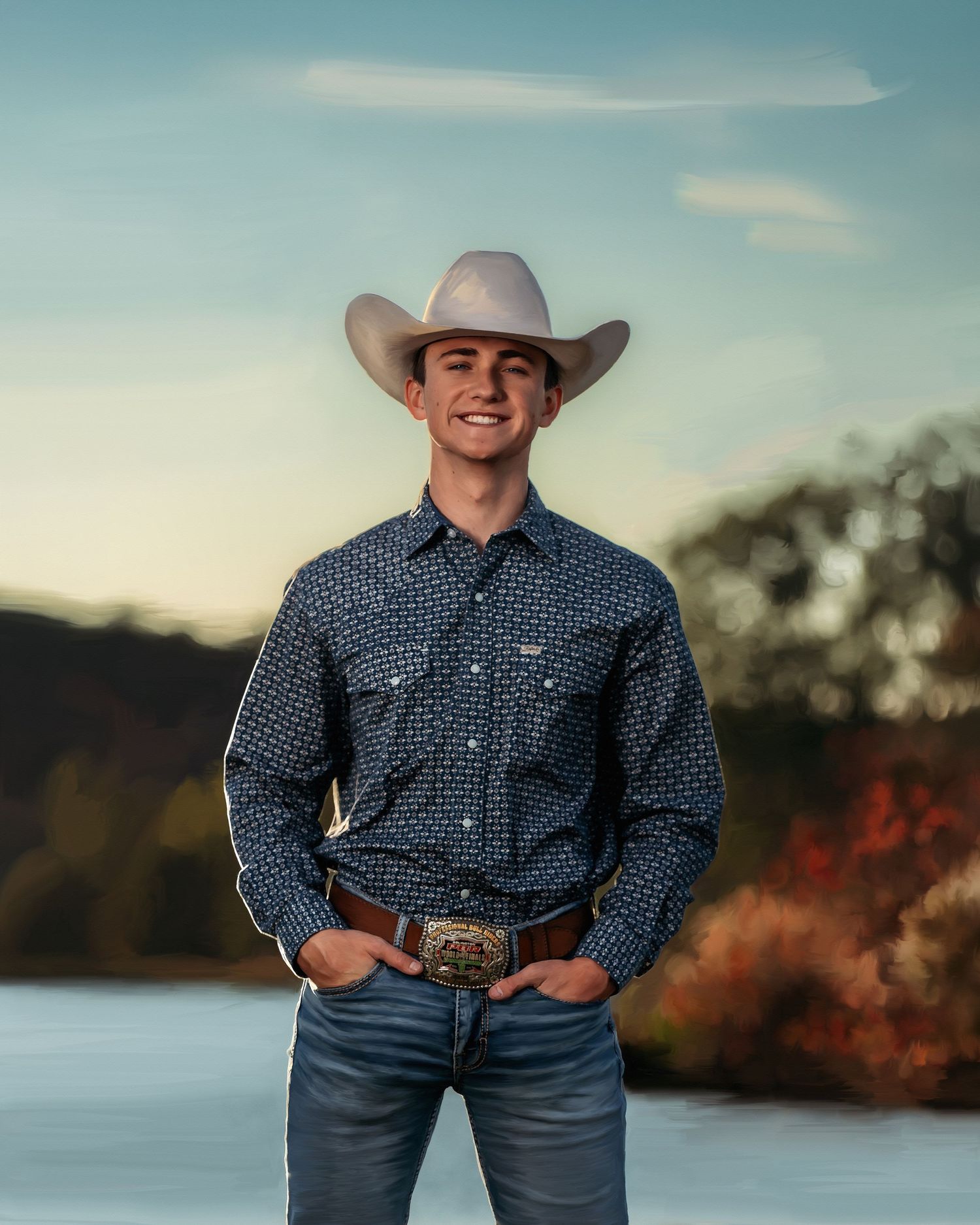 Young man in white cowboy hat, navy patterned western shirt, large belt buckle, and jeans smiling outdoors.