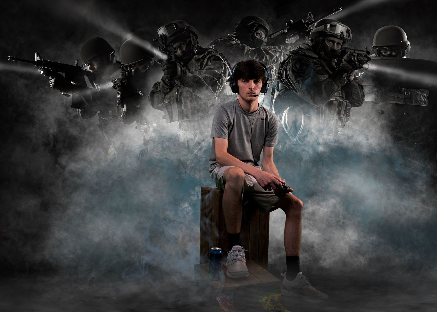 Teen boy sits on a box surrounded by dramatic smoke and military soldiers in an action-themed senior portrait.
