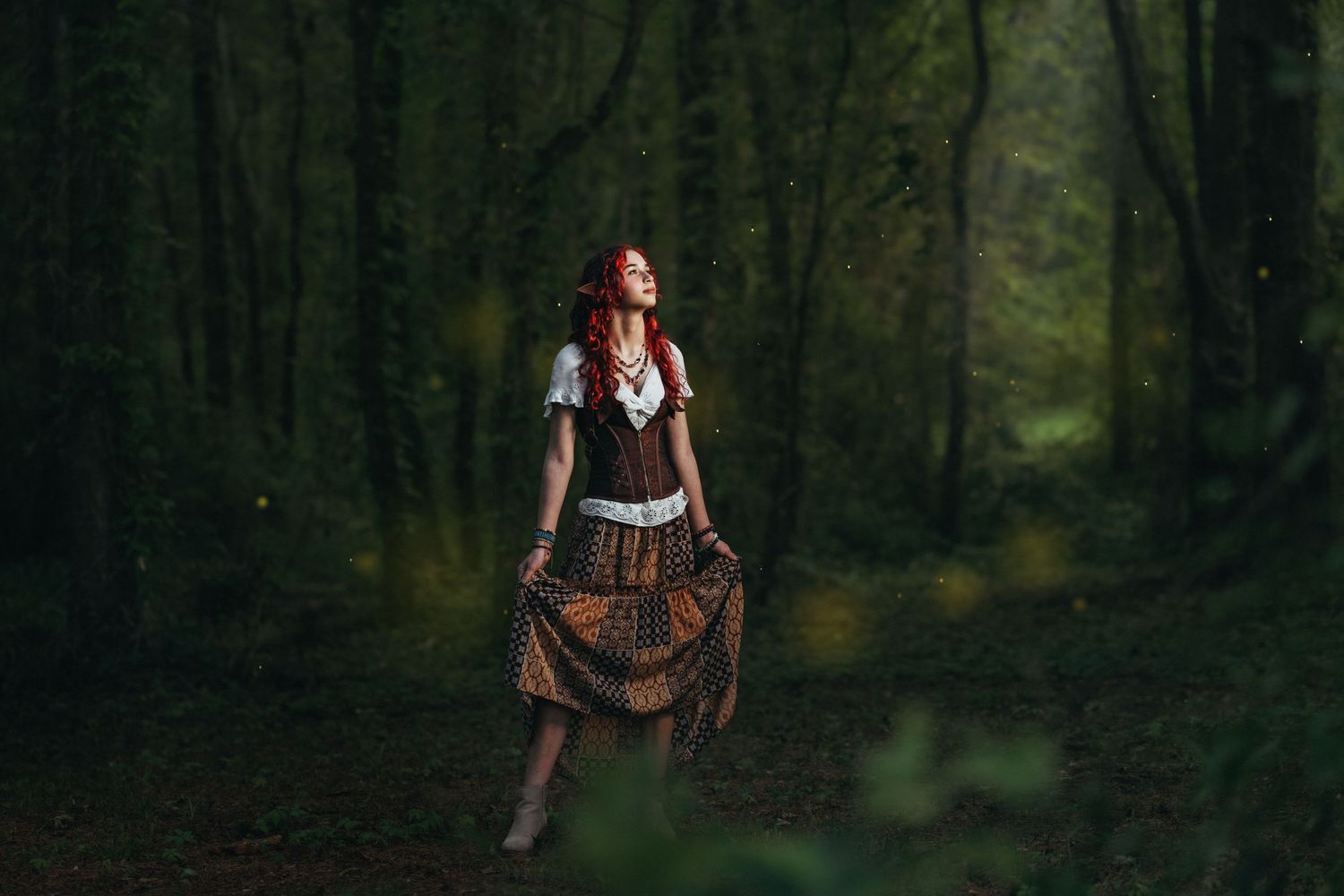 A redhead woman in a fantasy steampunk costume walks through a dark enchanted forest.