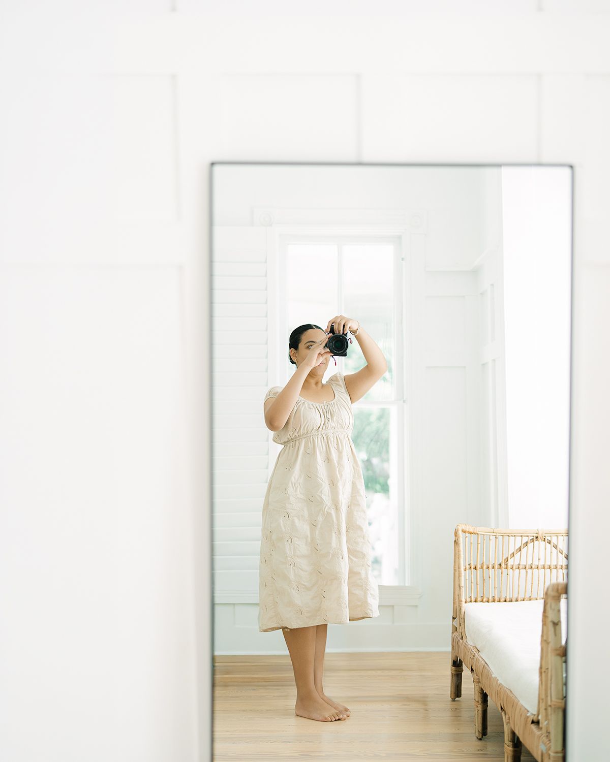 Photographer captures self-portrait in mirror wearing a beige linen dress indoors by Alahir Villasenor Photographer