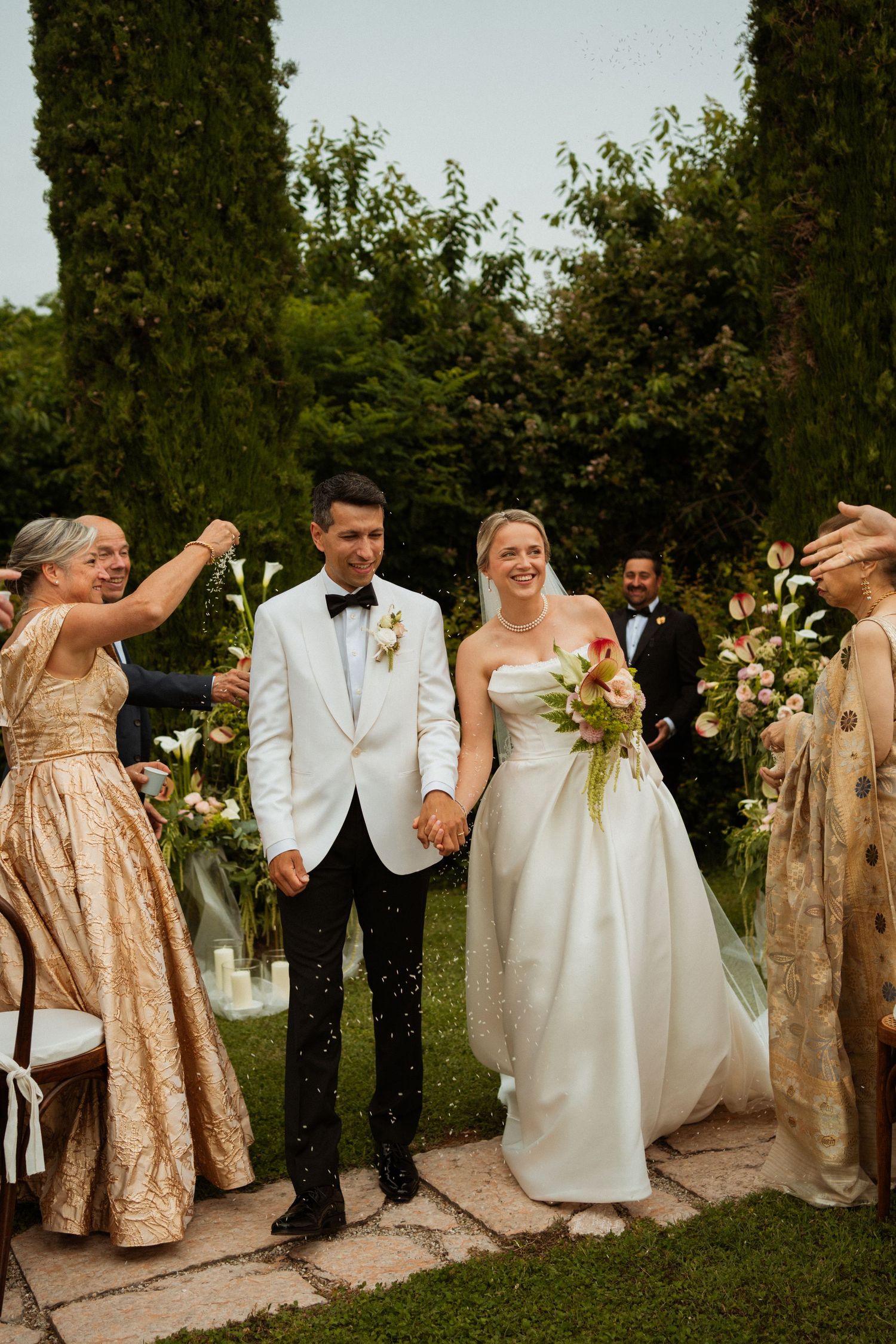 Bride and groom walk down the aisle hand in hand at an outdoor garden wedding ceremony.