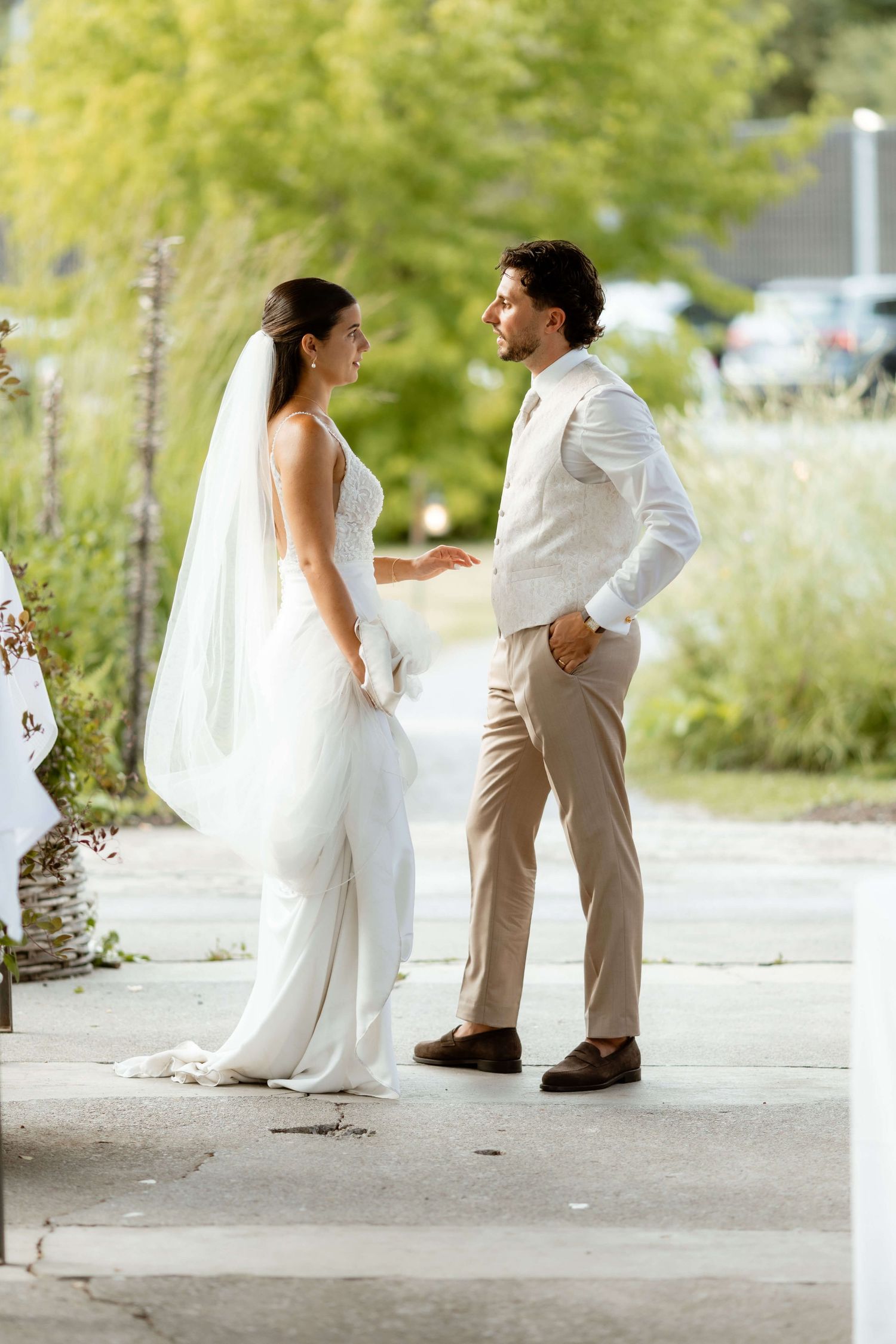 Bride and groom share a tender moment standing together on their wedding day outdoors.