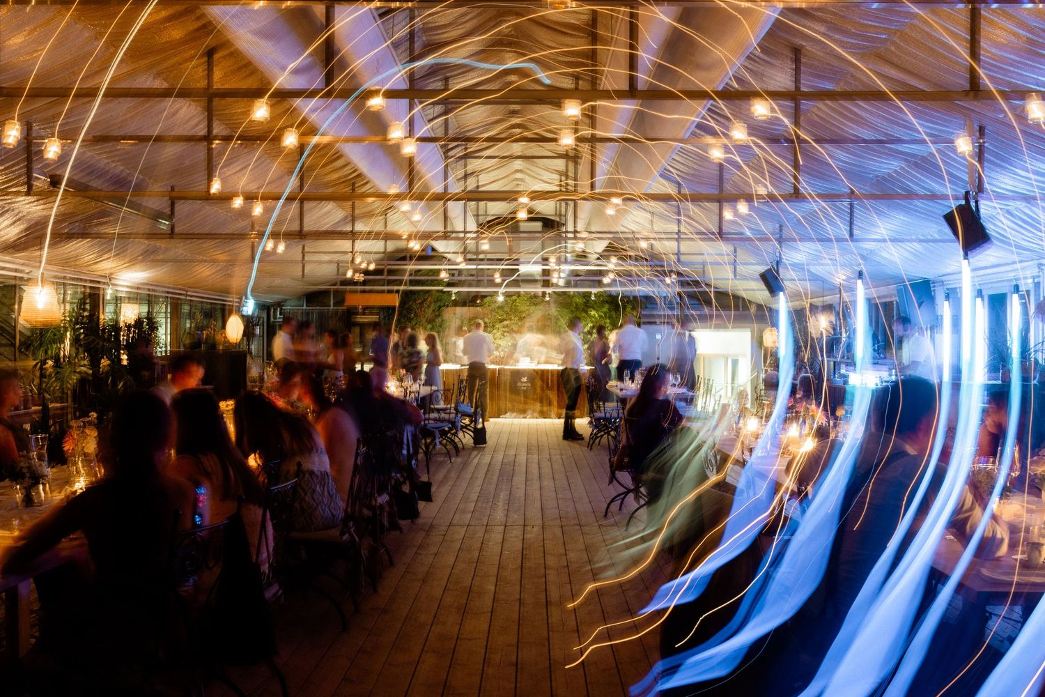 Long exposure photo of wedding reception venue creating swirling light trails effect.