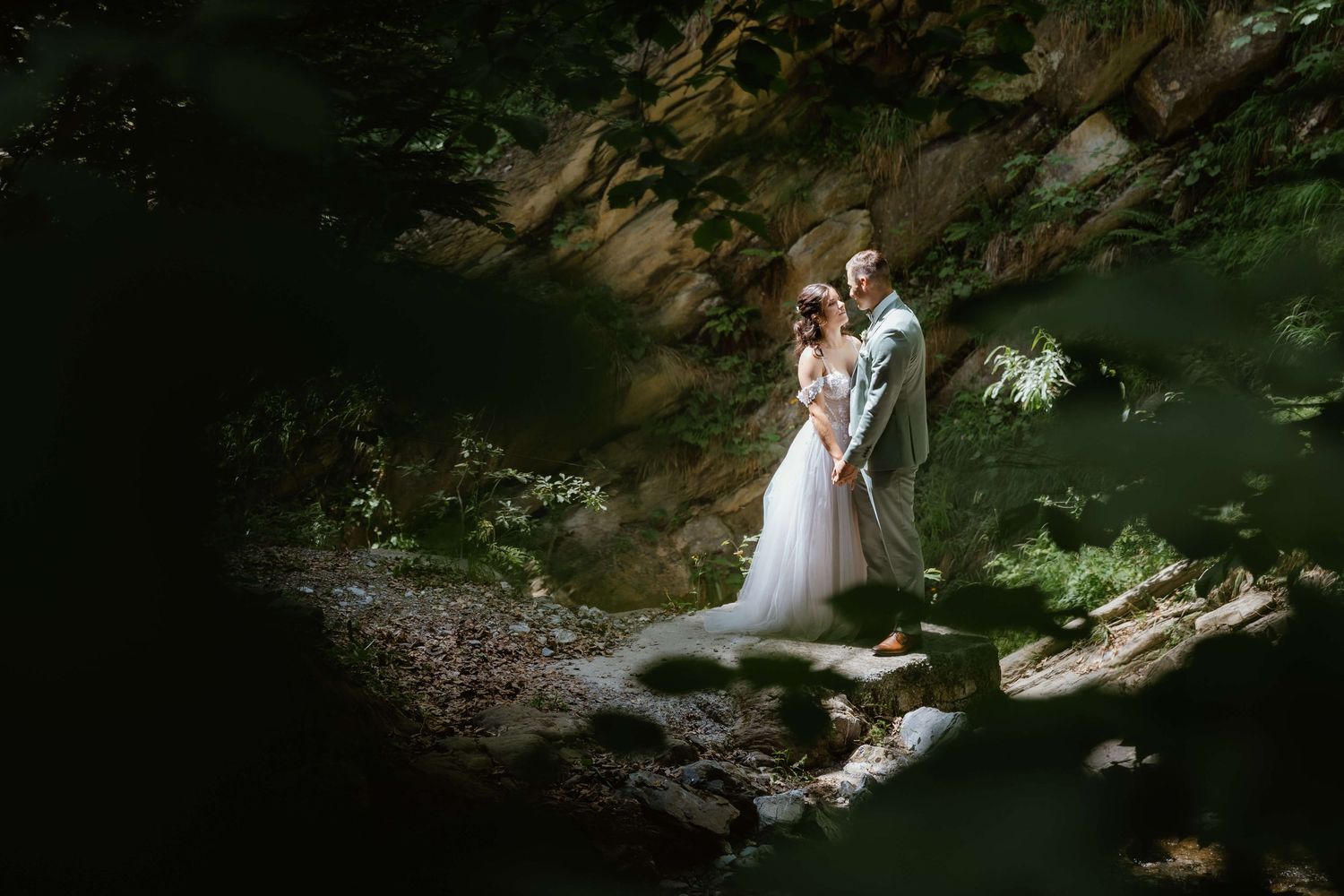 Brautpaar zwischen Felsen und Wald bei einer Hochzeit in Vorarlberg.