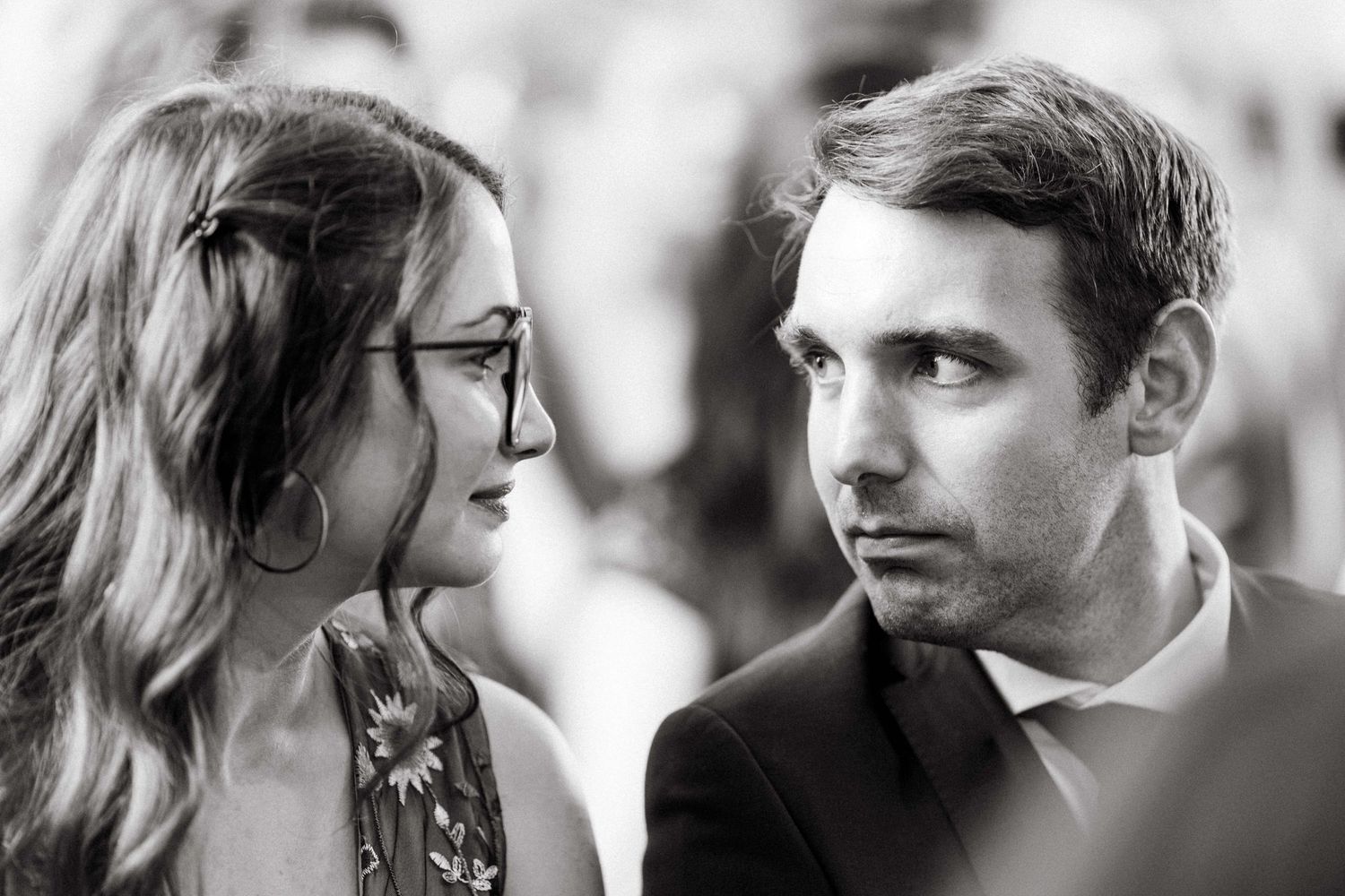 Black and white close-up portrait of a couple sharing an intimate moment at a wedding event.