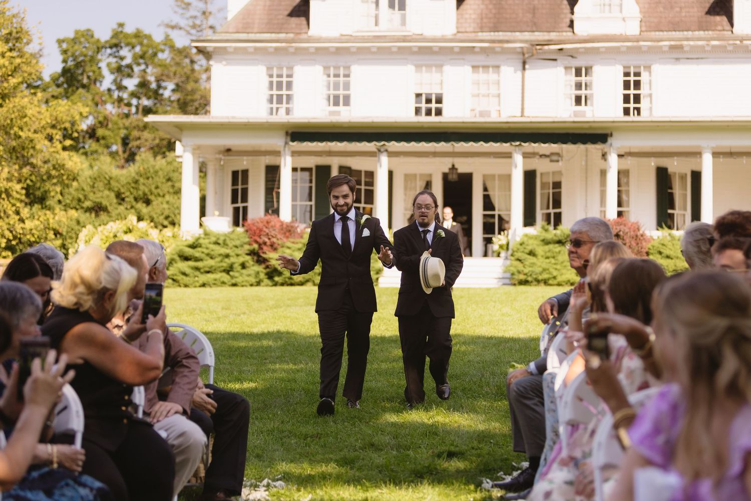 Groom and Best Man walking down the outdoor aisle at Wadsworth Homestead in Geneseo, NY.