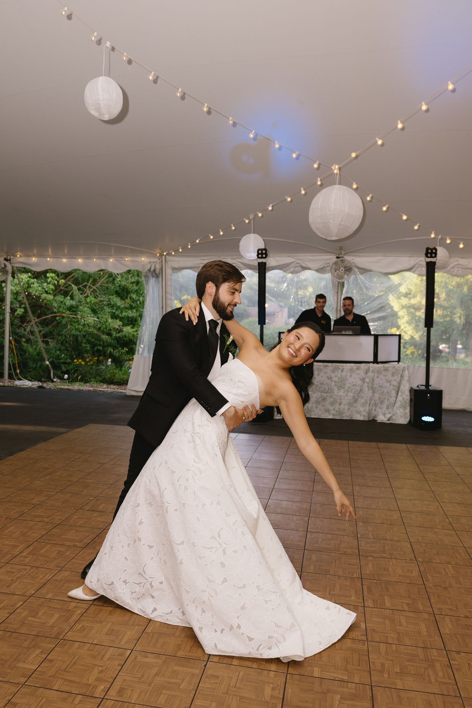 Groom dipping bride during first dance under tent lights at Wadsworth Homestead wedding reception in Geneseo, NY.