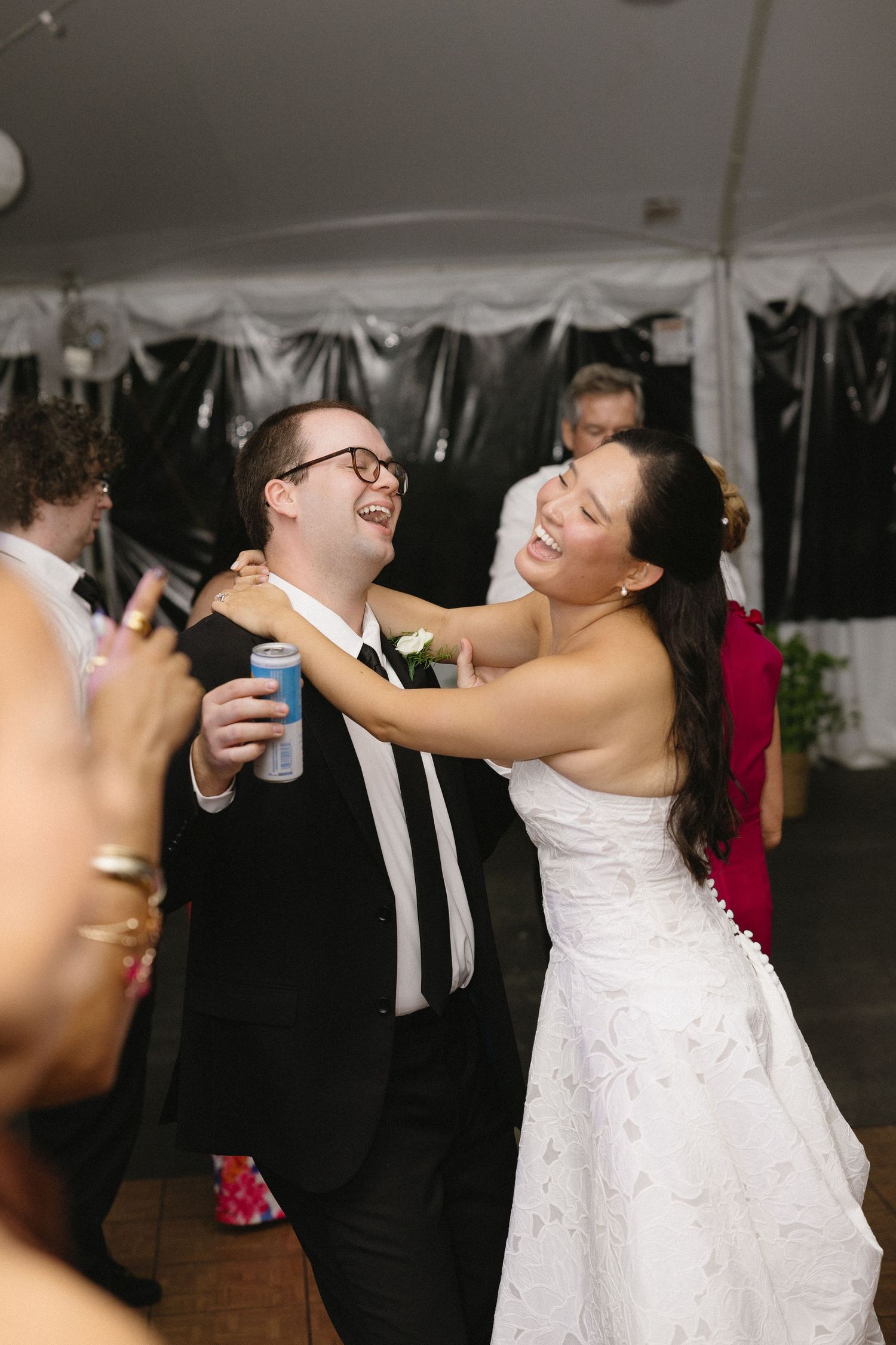 Bride laughing and dancing with a guest during a tented wedding reception at Wadsworth Homestead in Geneseo, NY.