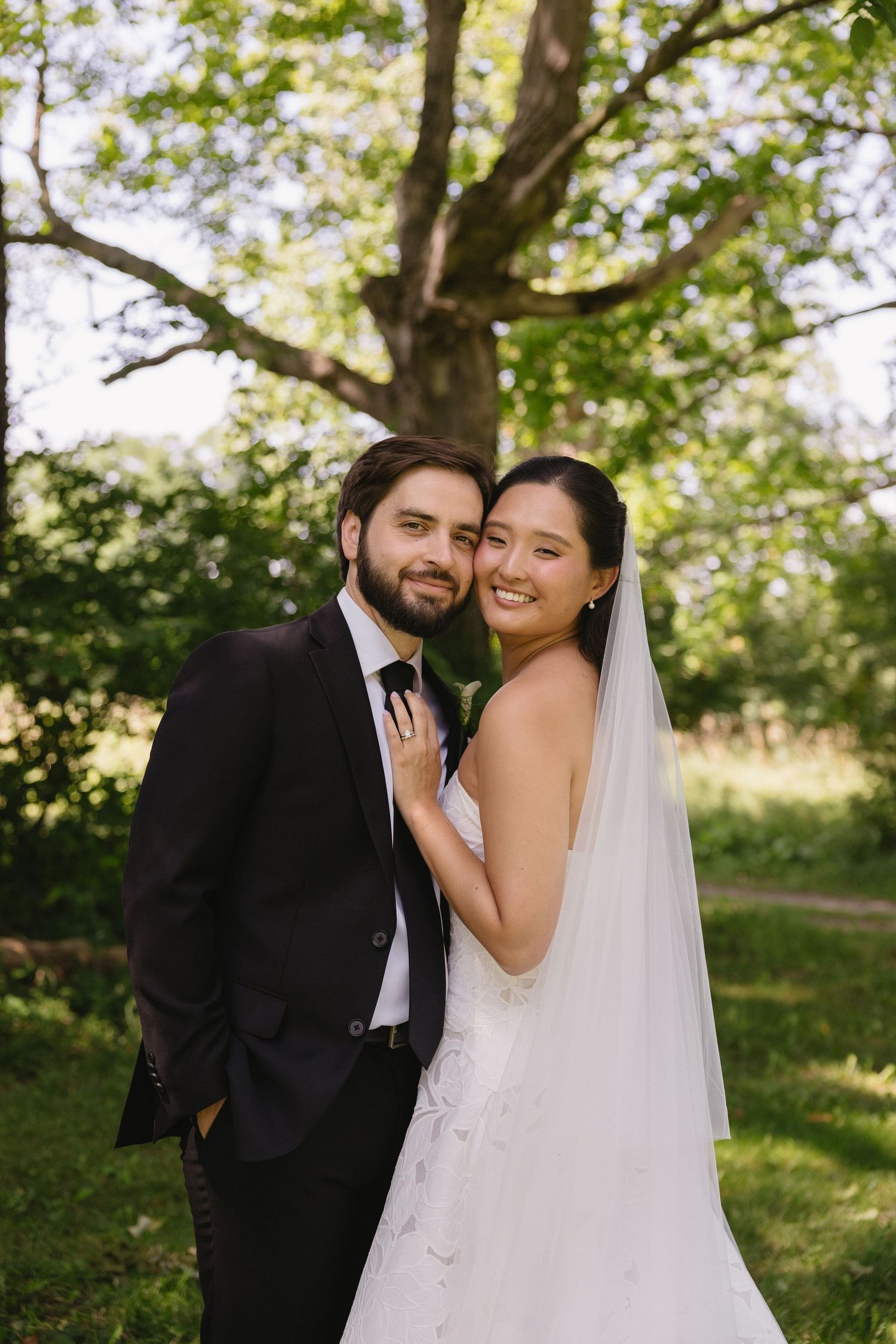 Bride and groom smiling at the camera together outdoors at Wadsworth Homestead in Geneseo, NY.