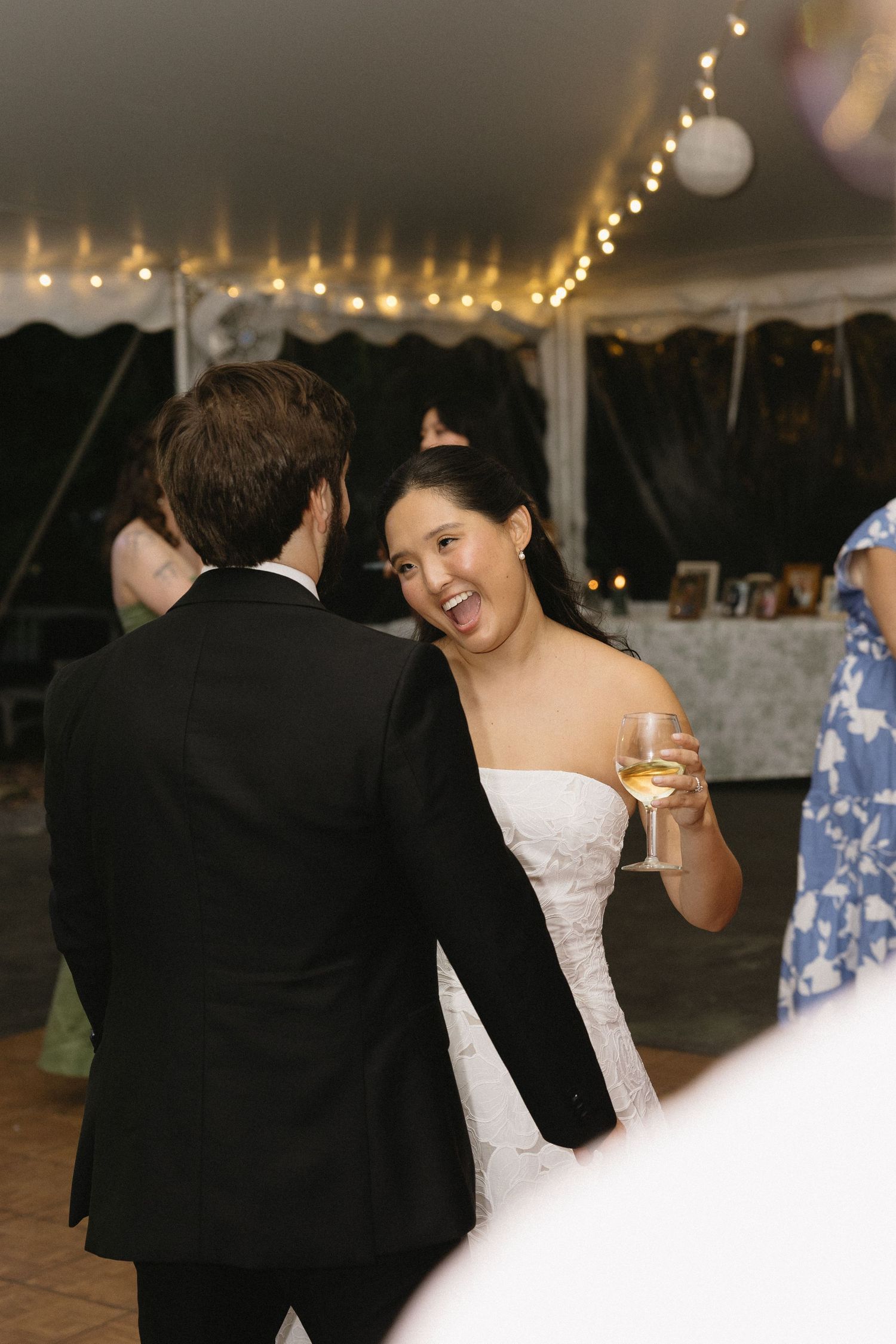 Wadsworth Homestead Geneseo NY tent wedding reception dance floor candid of bride and groom with wine glass and fairy lights.