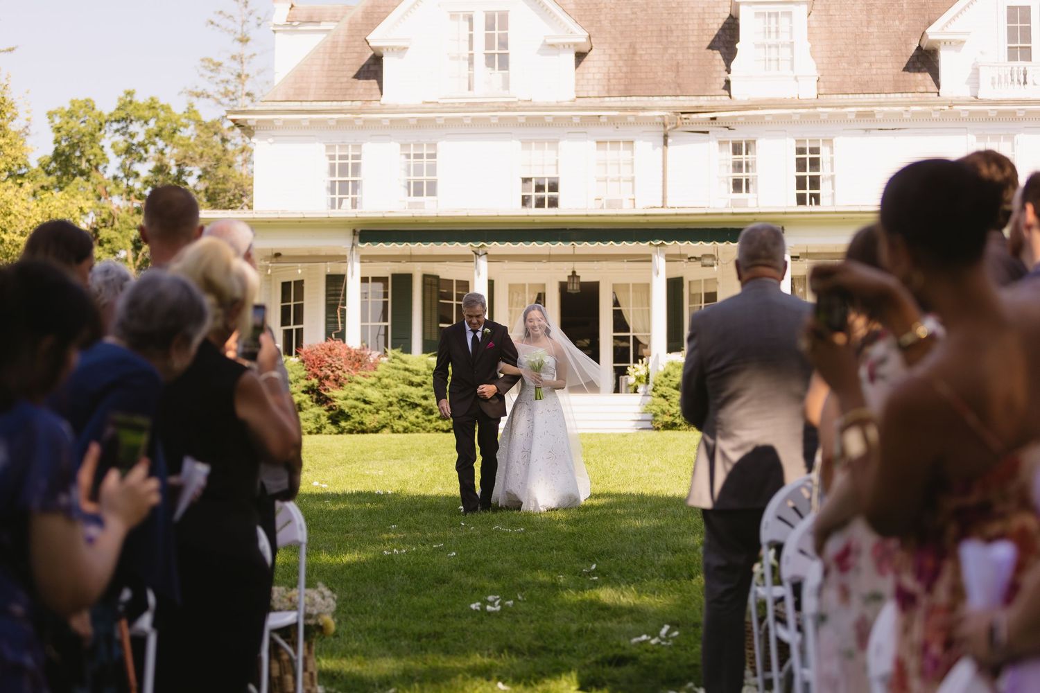 Bride walking down the outdoor aisle with her father at Wadsworth Homestead in Geneseo, NY.