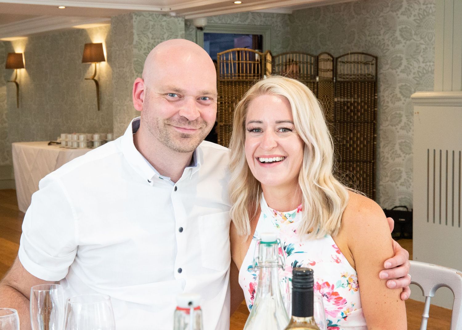 Smiling couple posing together at elegant indoor wedding reception venue.