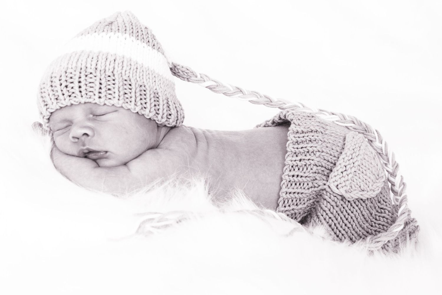 Pencil sketch of sleeping newborn baby wearing knit hat and diaper cover.