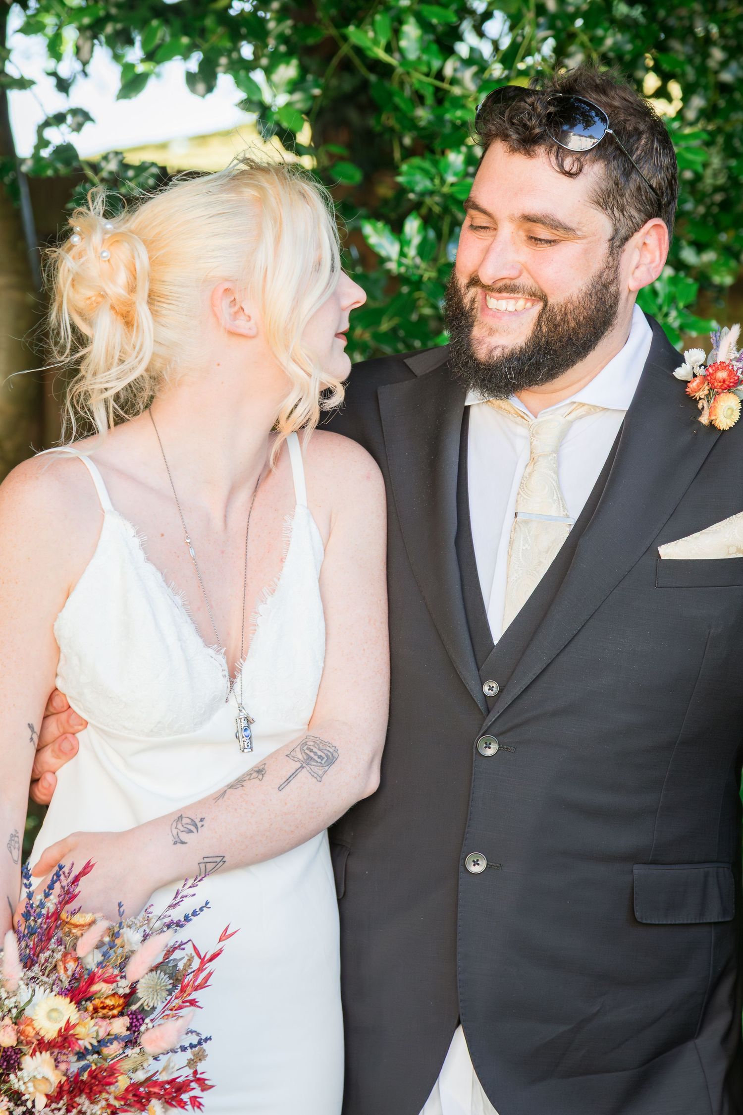 Smiling bride and bearded groom sharing a joyful moment at wedding.