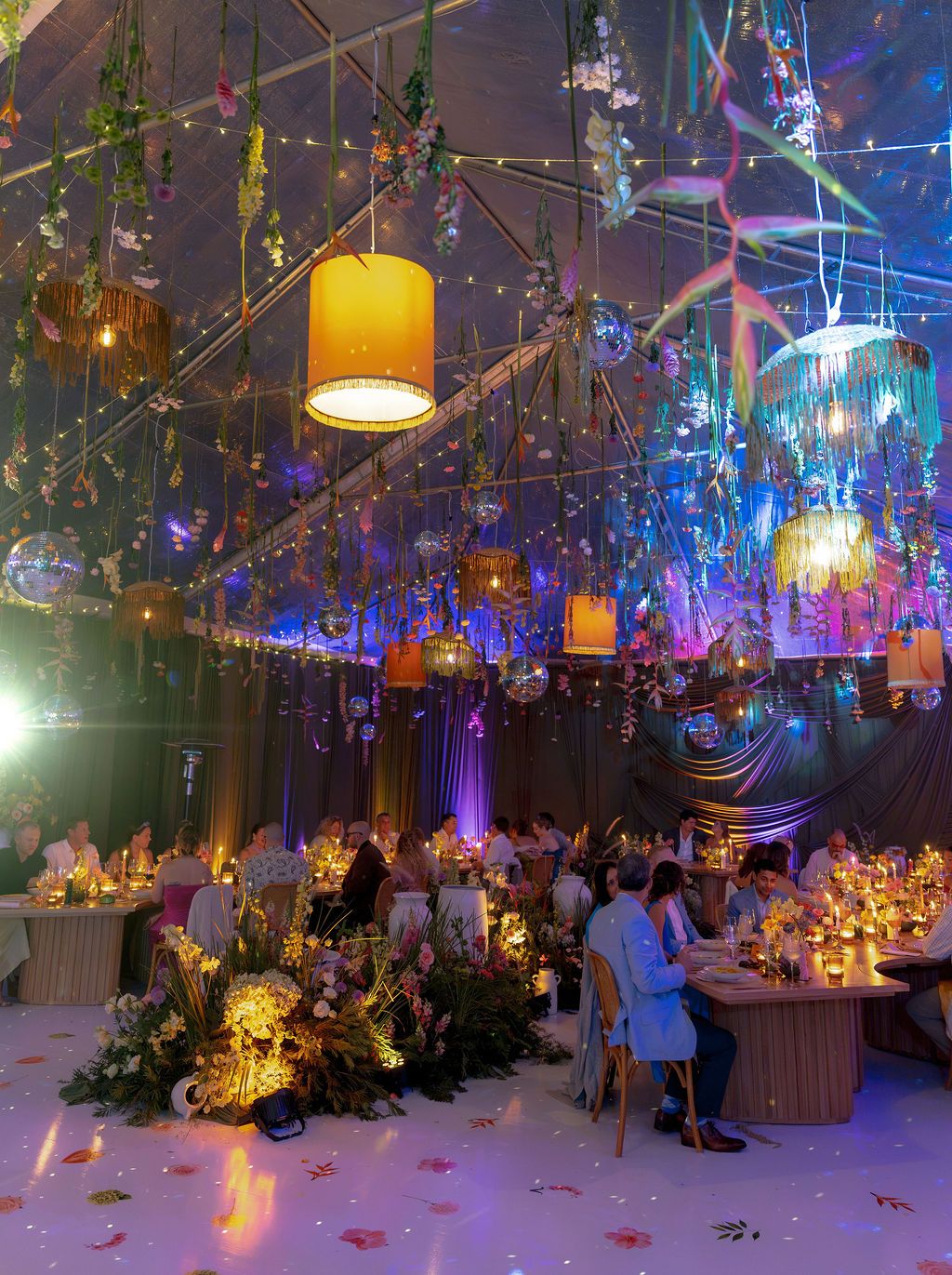 Colorful destination wedding reception filled with hanging flowers, lanterns, disco balls, and tropical florals in Costa Rica