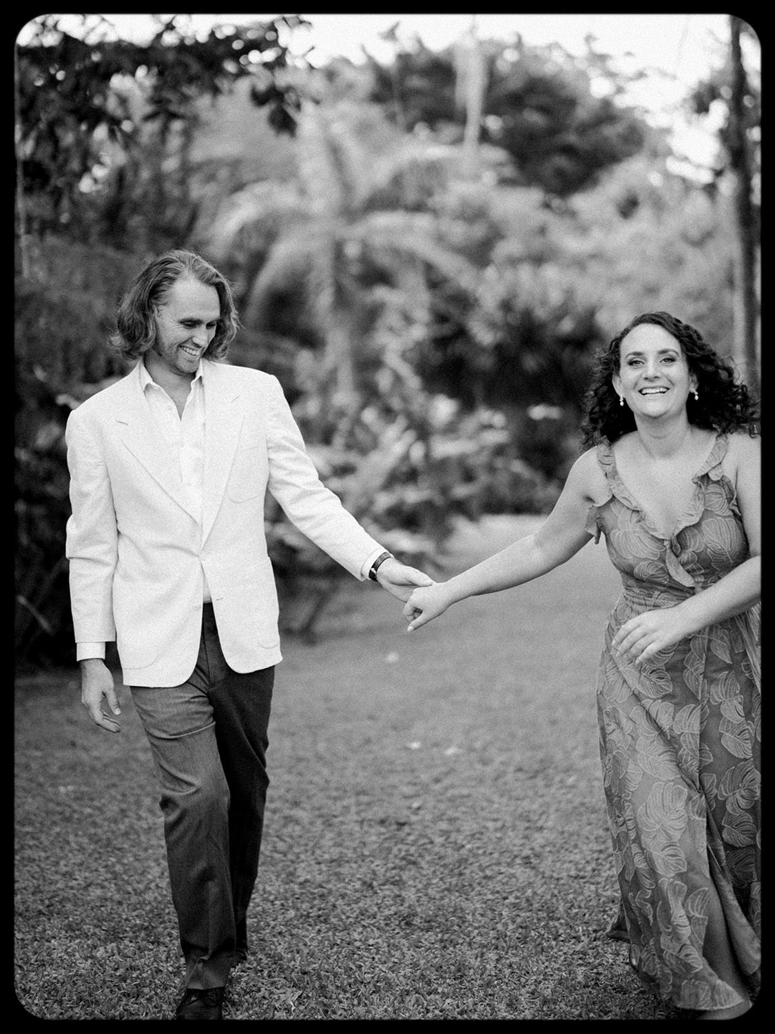 Black and white film portrait of a couple holding hands during a celebration in Costa Rica.