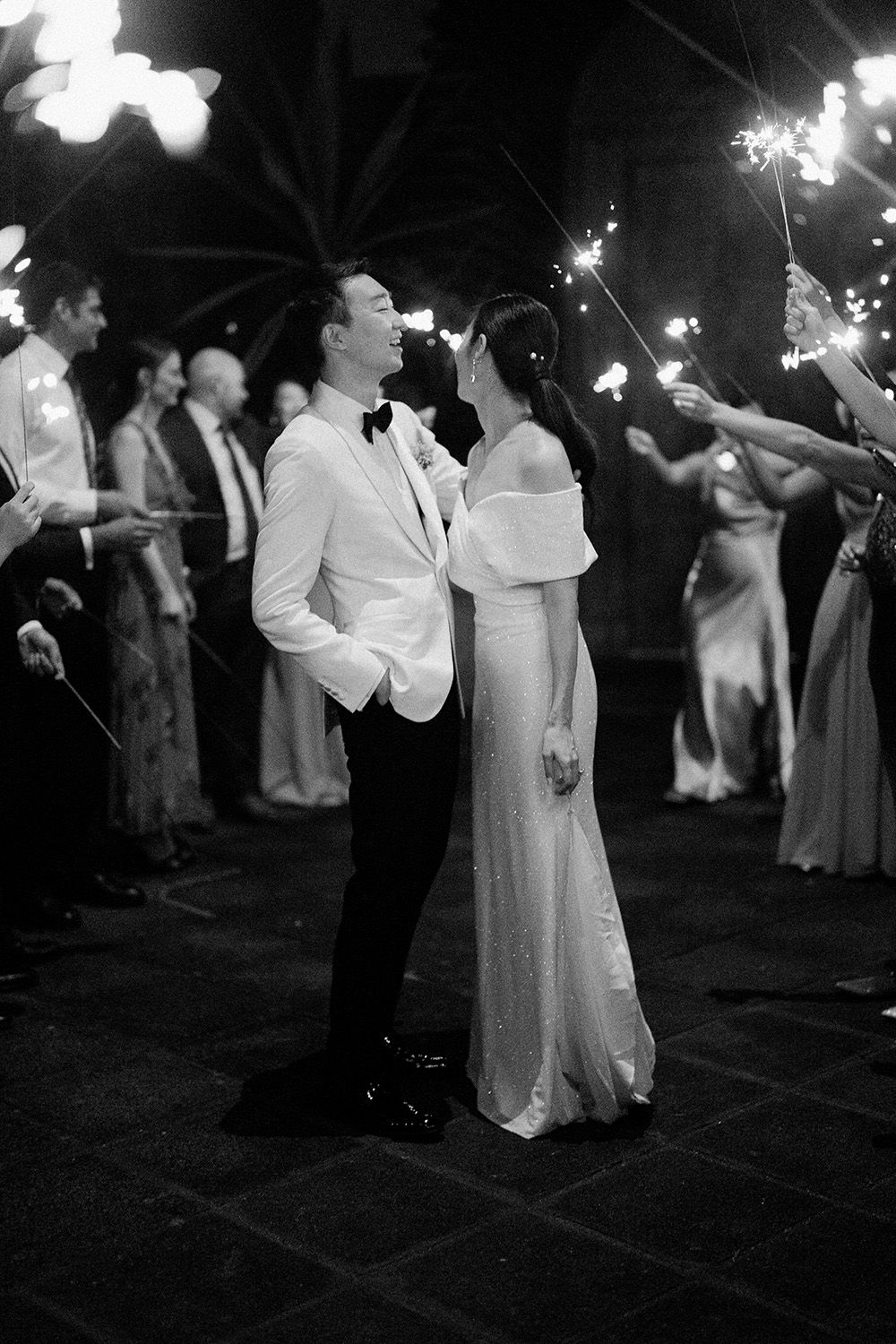 Bride and groom surrounded by guests holding sparklers during their Costa Rica wedding reception.