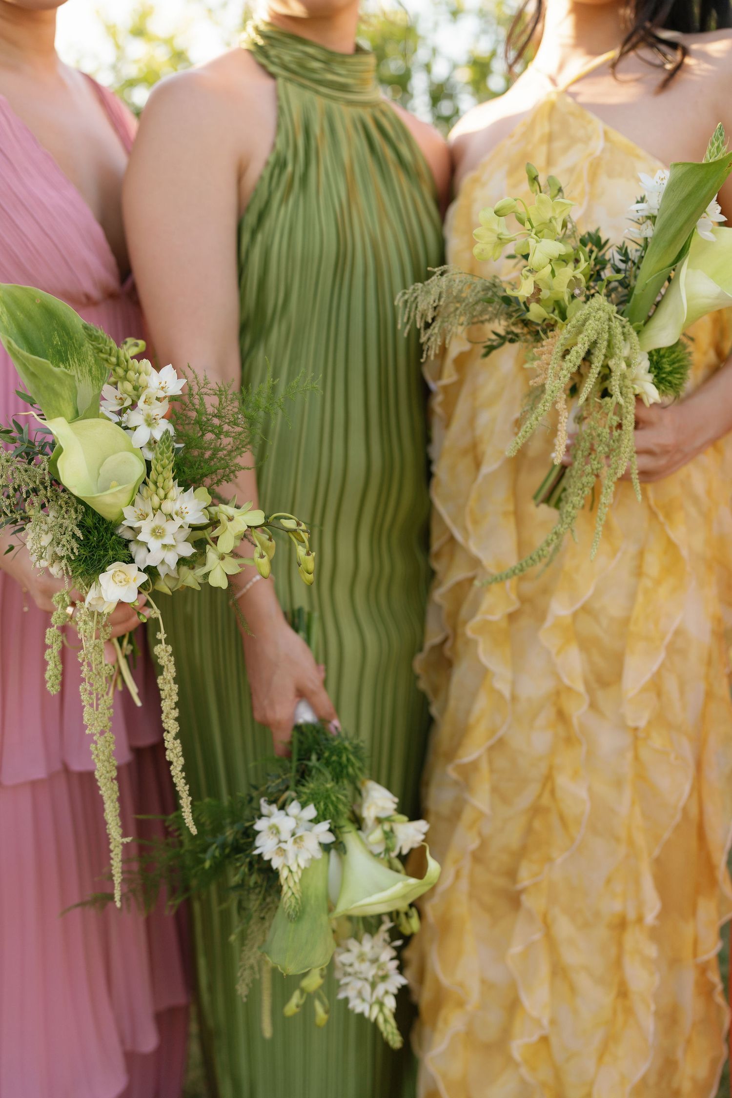 White and green bridesmaid bouquets with colorful dresses at a Guanacaste wedding