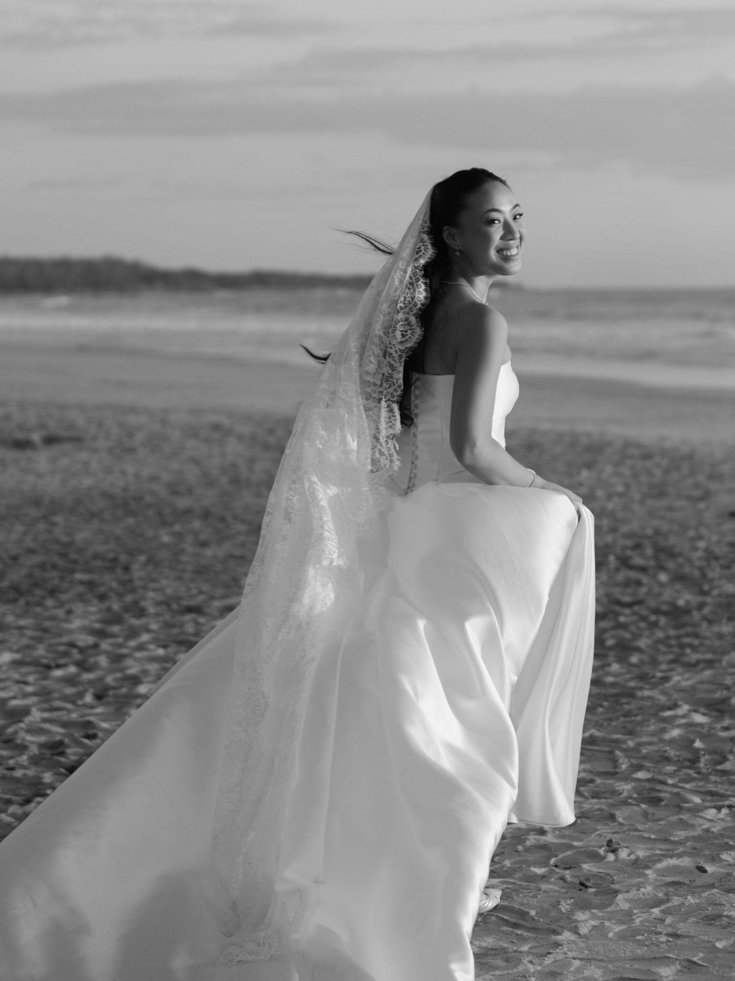 Black and white bridal portrait of Ashley walking along the beach in Guanacaste