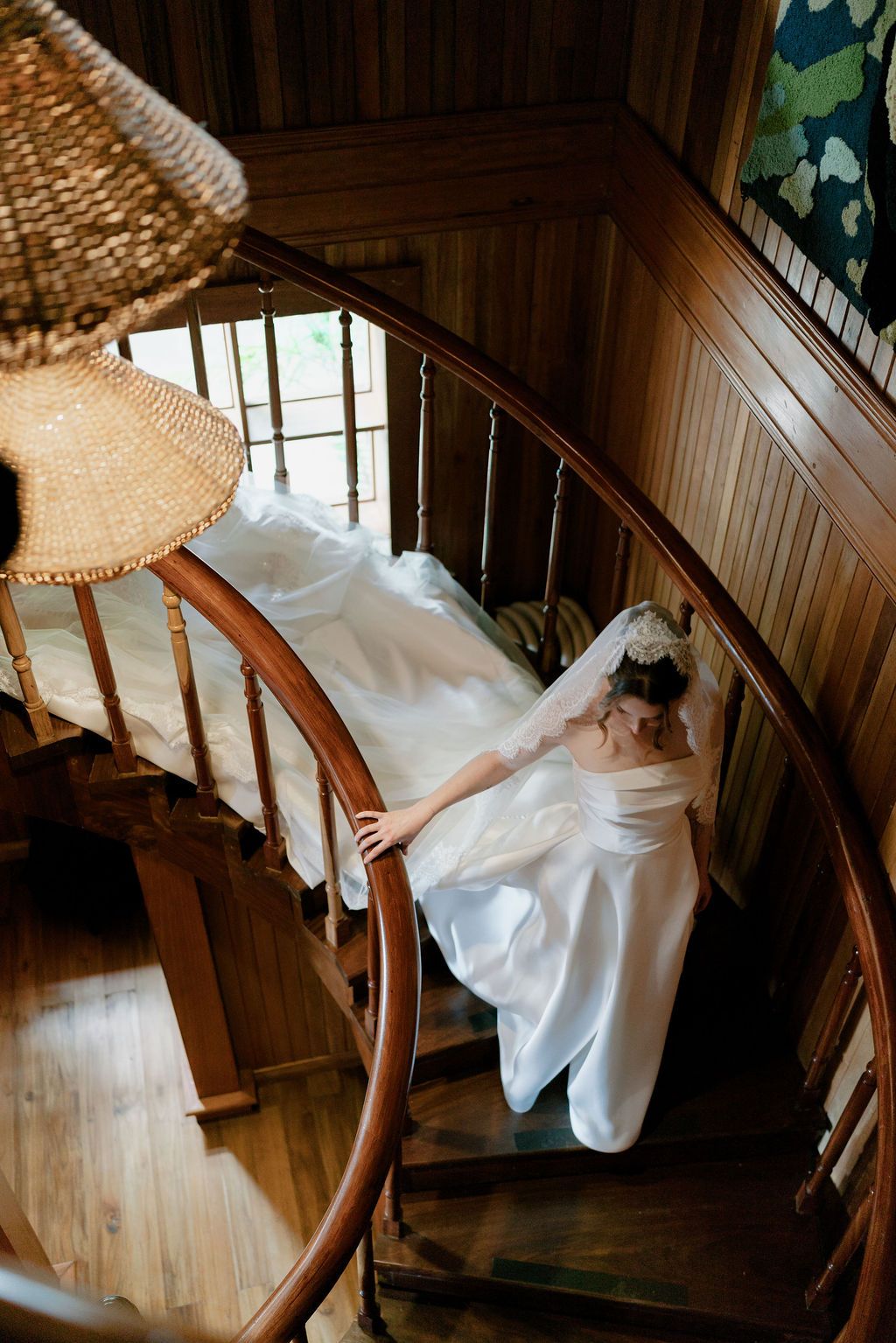 Bride walking down a wooden staircase in her wedding gown in Monteverde