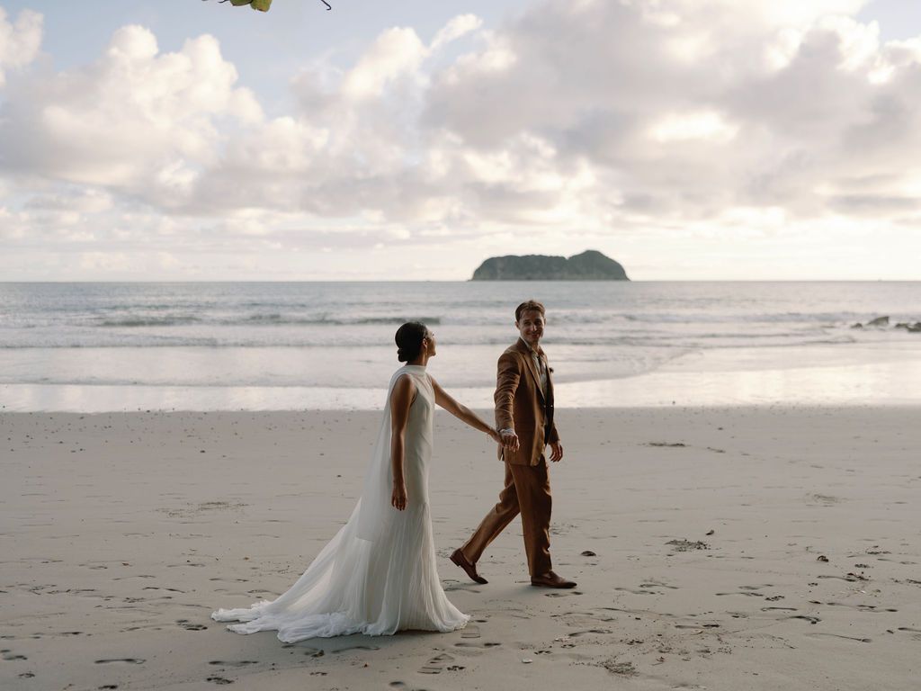 Couple walking hand in hand along the beach in Manuel Antonio, Costa Rica.