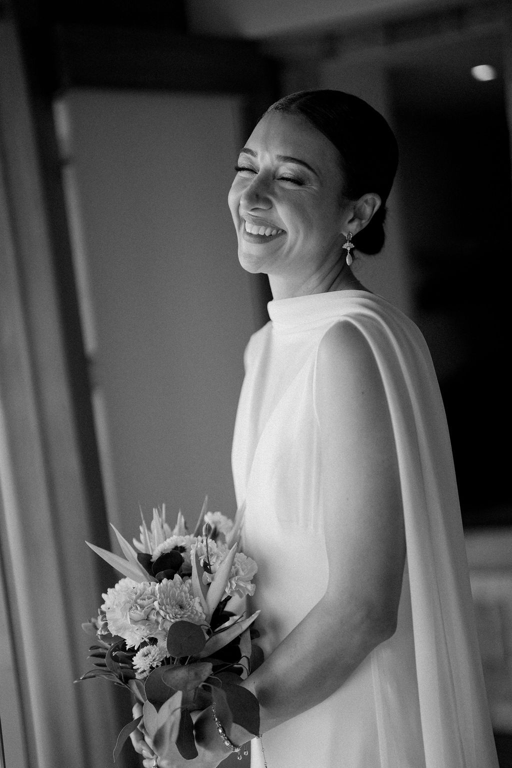 Black-and-white portrait of the bride smiling with her bouquet at Villa Punto de Vista.