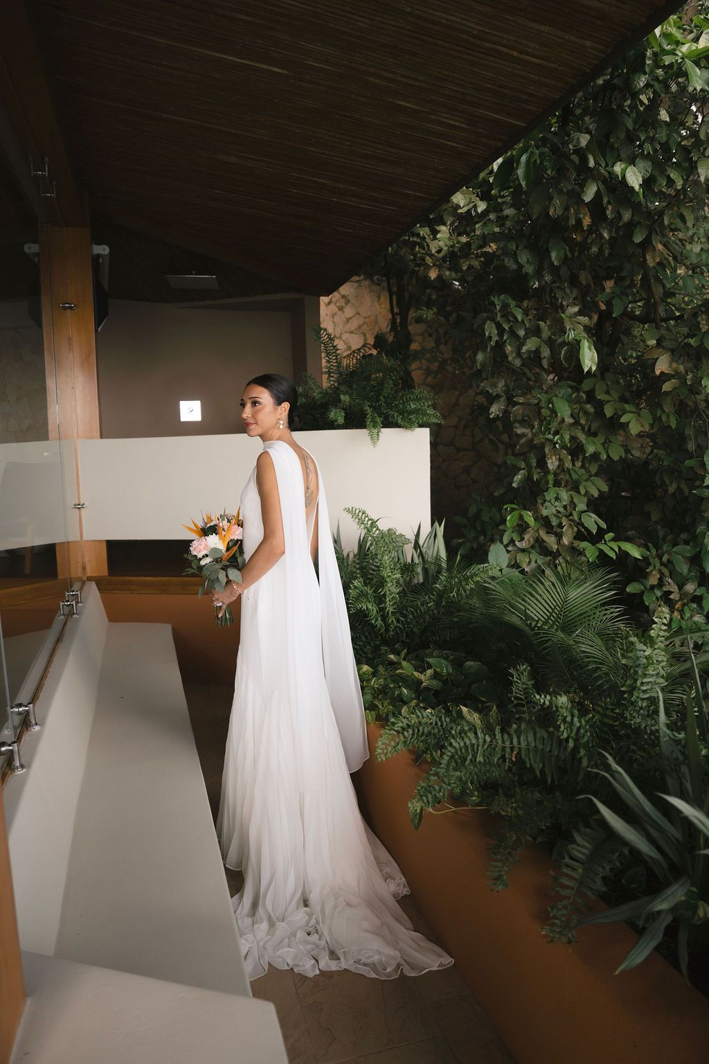 Bride in a flowing white gown surrounded by tropical greenery in Manuel Antonio.